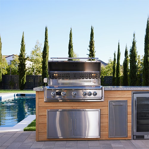 Blaze marine grade outdoor kitchen storage components in an outdoor kitchen island near a pool