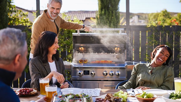 Grilling on a Blaze LTE PRO Gas grill with friends in the backyard