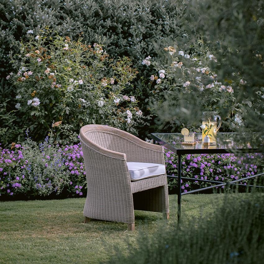 Cambria Teak Dining Arm Chair in Light Wood/Canvas Canvas by Sunset West - Shown in Garden Wide Shot - Lifestyle thumbnail