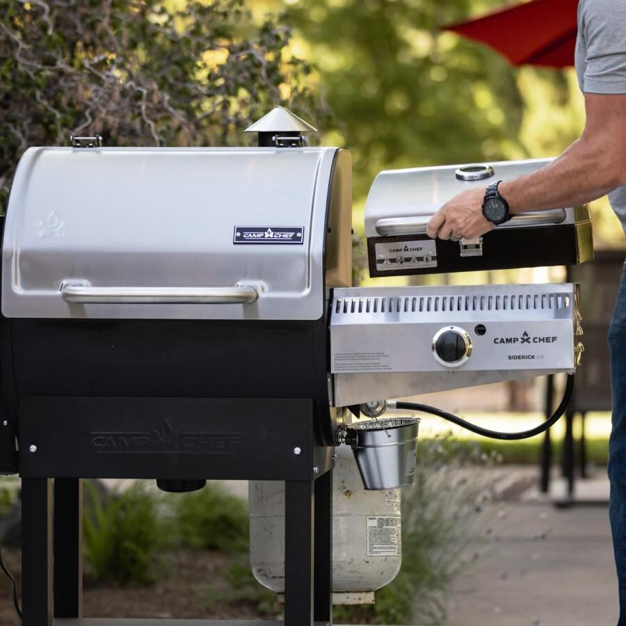 Camp Chef PG24WWSB + PG14BB Woodwind Pro WiFi 24-Inch Pellet Grill With Propane Sidekick Sear Box - 14-Inch Sidekick Sear Station - Lifestyle - Placing BBQ Box On Sidekick Burner thumbnail