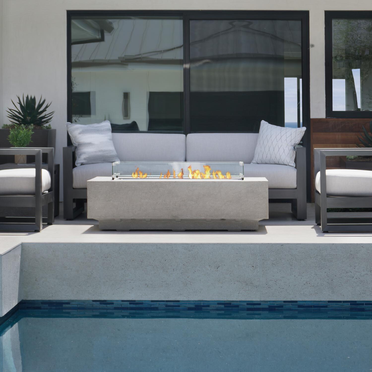 Gravelstone 60-Inch Rectangular Natural Gas Fire Table with Glass Surround by Sunset West - Lifestyle thumbnail