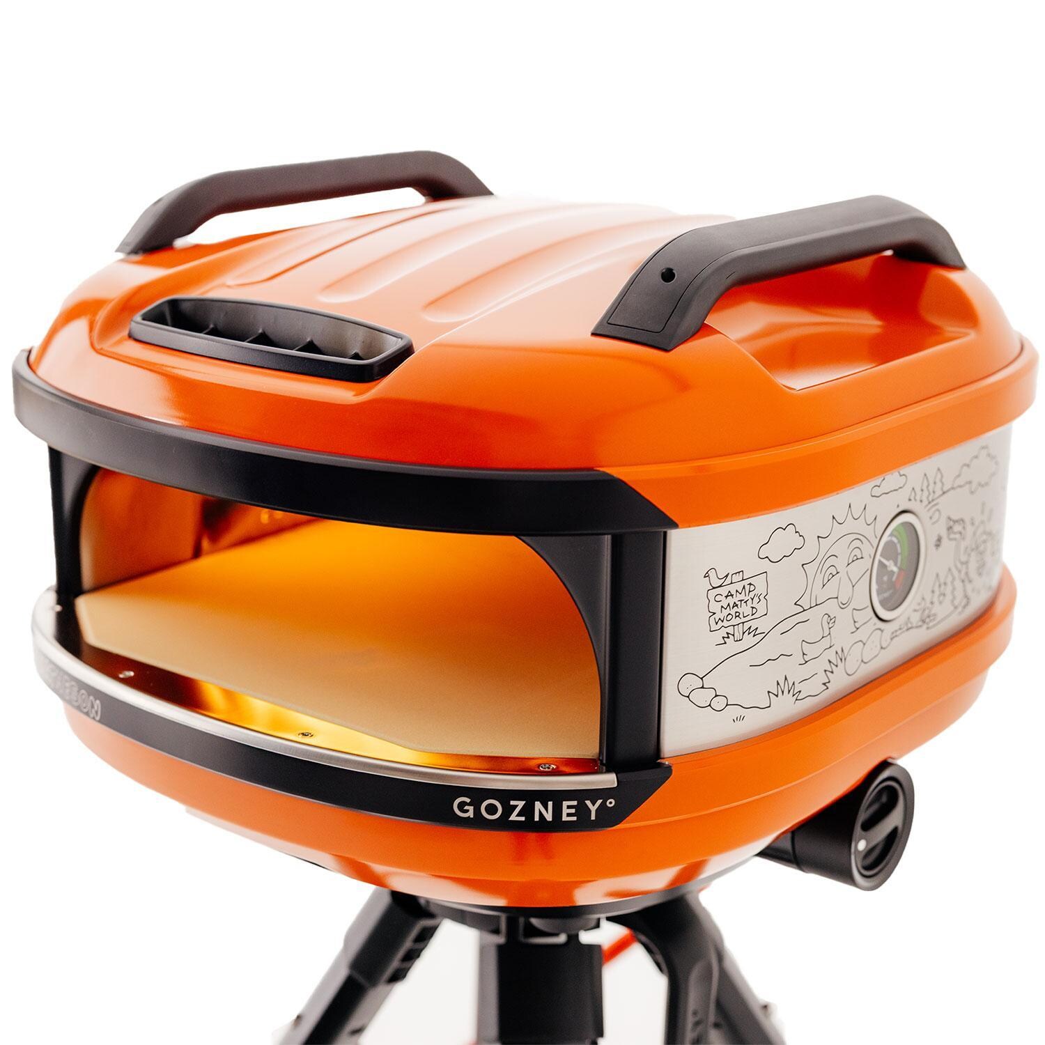 Matty Matheson x Gozney GTPOGUS1225 Limited-Edition Tread Portable Propane Pizza Oven - Orange - On Tread Stand - Angled w/ Temperature Gauge Shown - White Background thumbnail