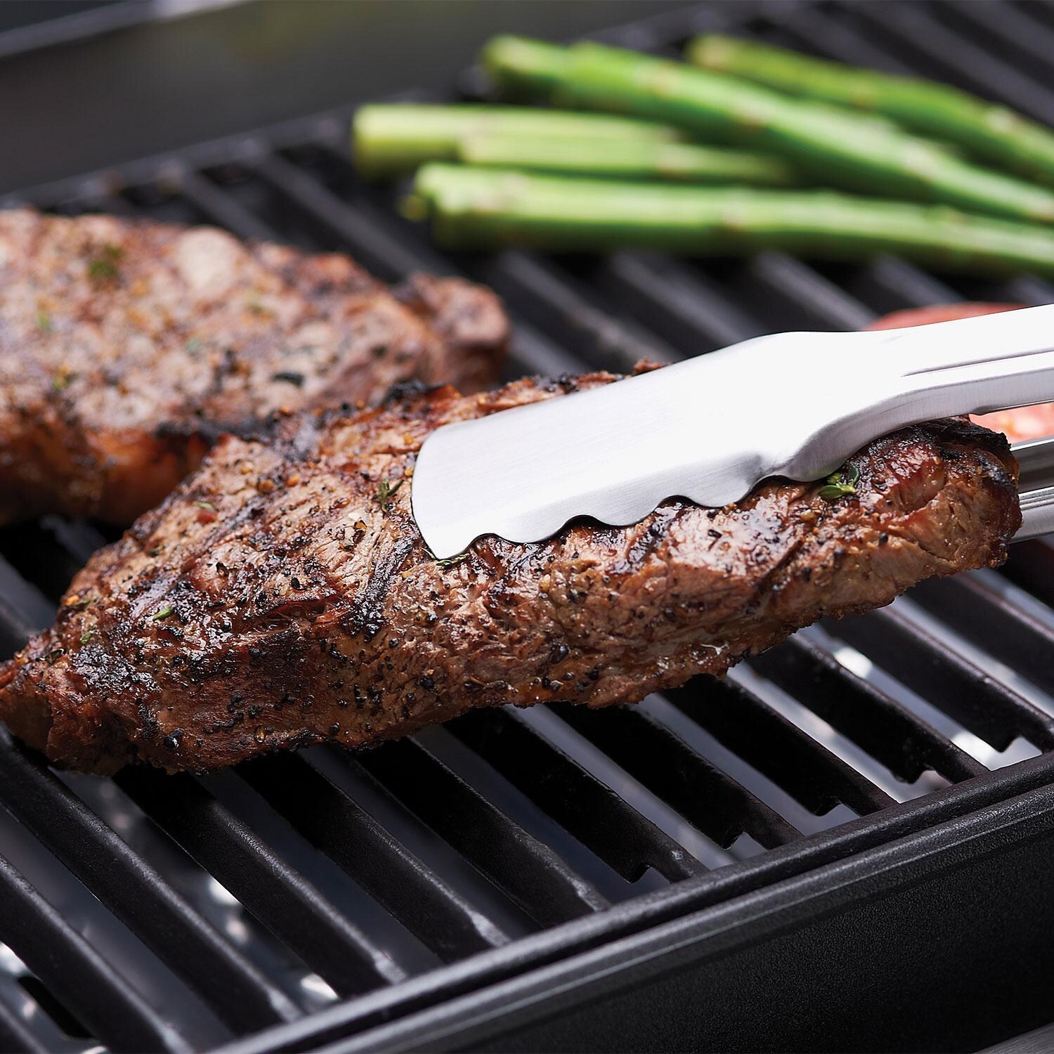 Broil King 11227 14 x 12 2 Pc Cast Iron Cooking Grids - Taking Steaks off Grid W/ Tongs - Lifestyle thumbnail