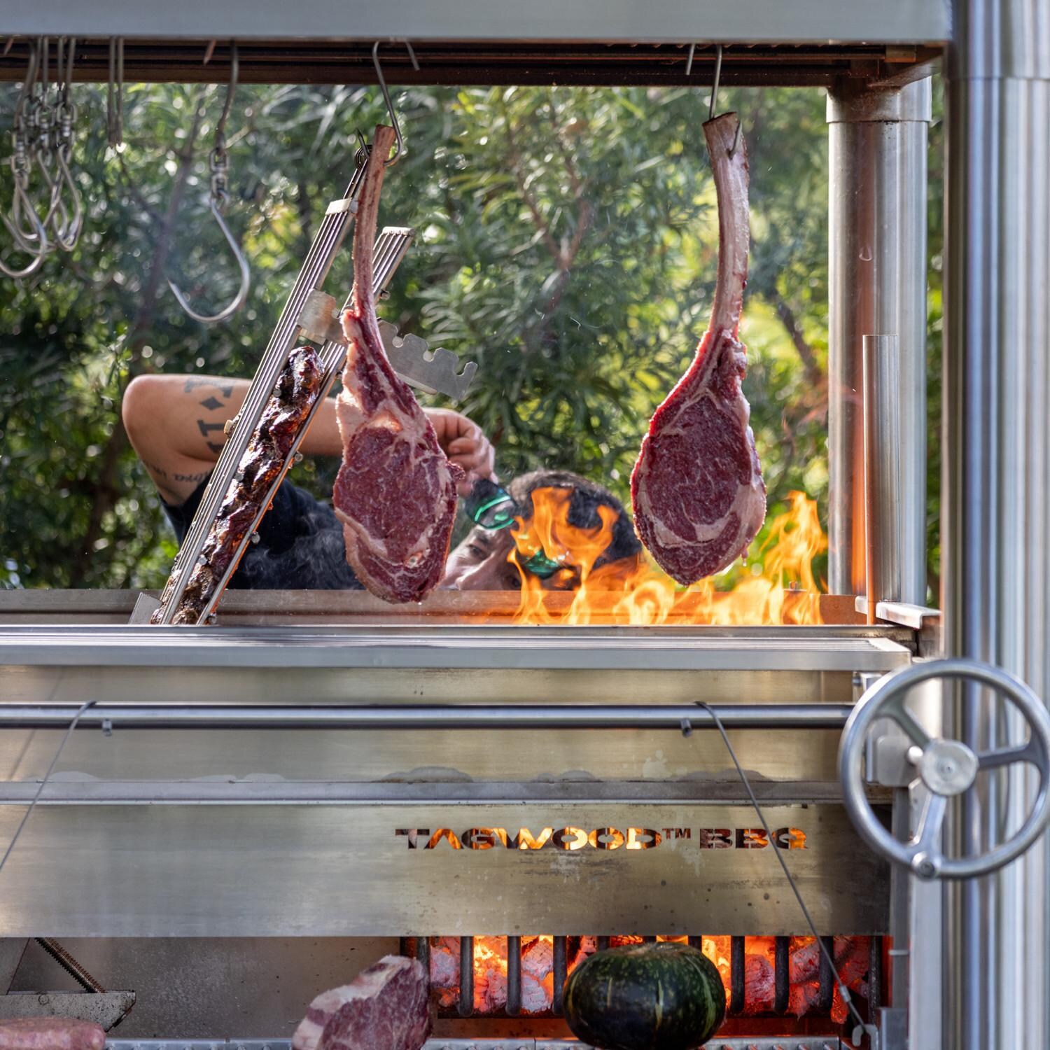 Tagwood BBQ02SS BBQ Silver Bullet All Stainless Steel Argentine Wood Fire & Charcoal Grill - In Use Up Close thumbnail