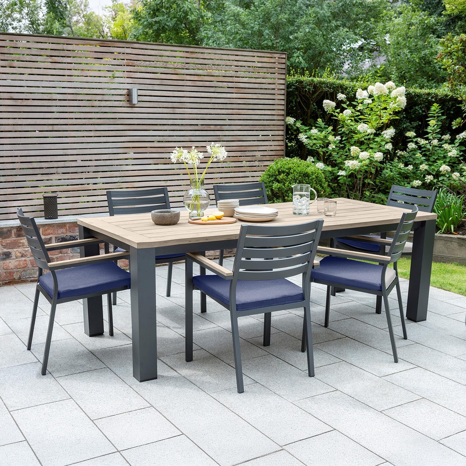 Elba 7 Pc Aluminum Dining Set w/ Teak Tabletop in Charcoal / Spectrum Indigo - On Patio - Lifestyle thumbnail
