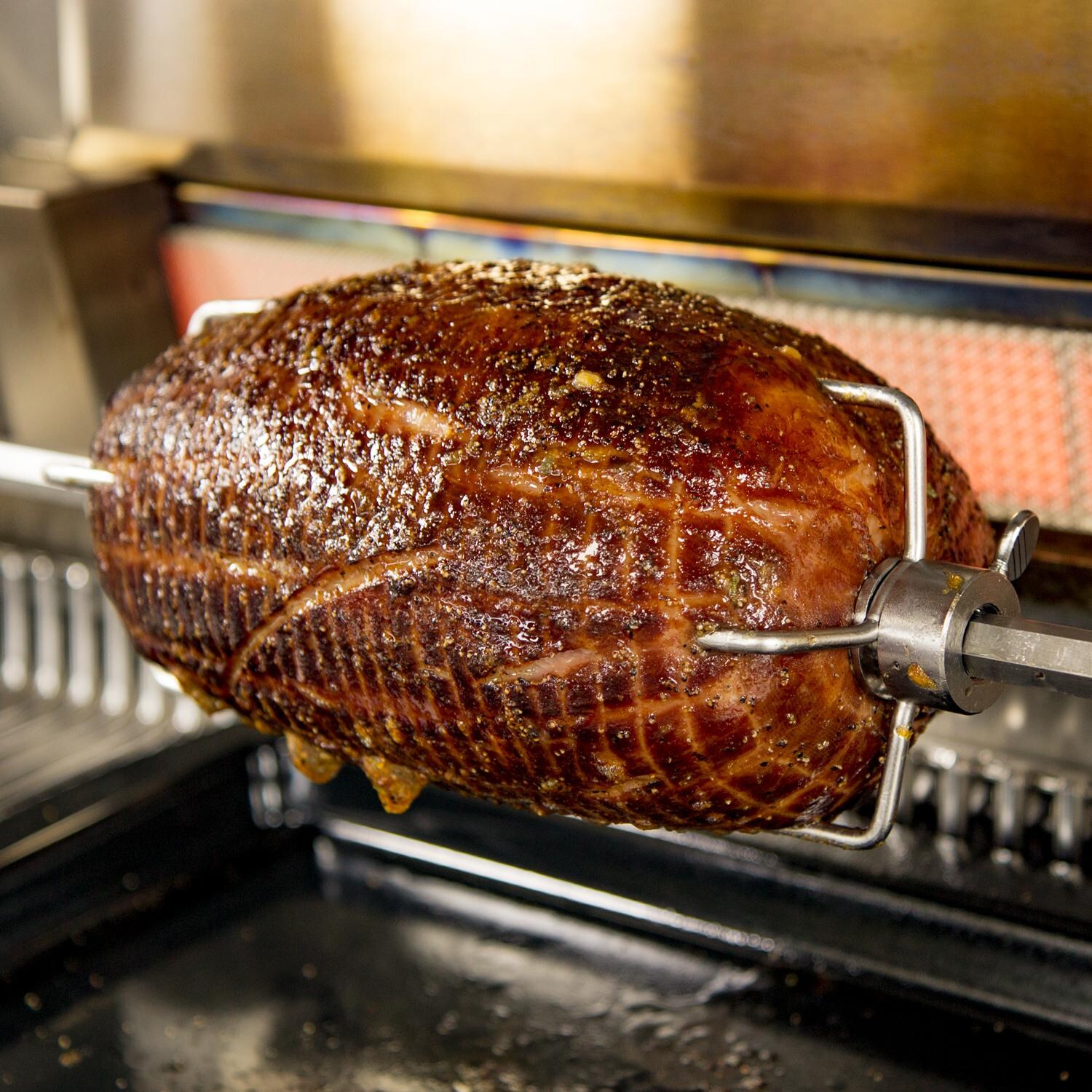 Caliber CrossFlame Pro 42-Inch Built-In Propane Gas Grill With Sear Burner And Rotisserie - Glazed Ham On The Rotisserie thumbnail
