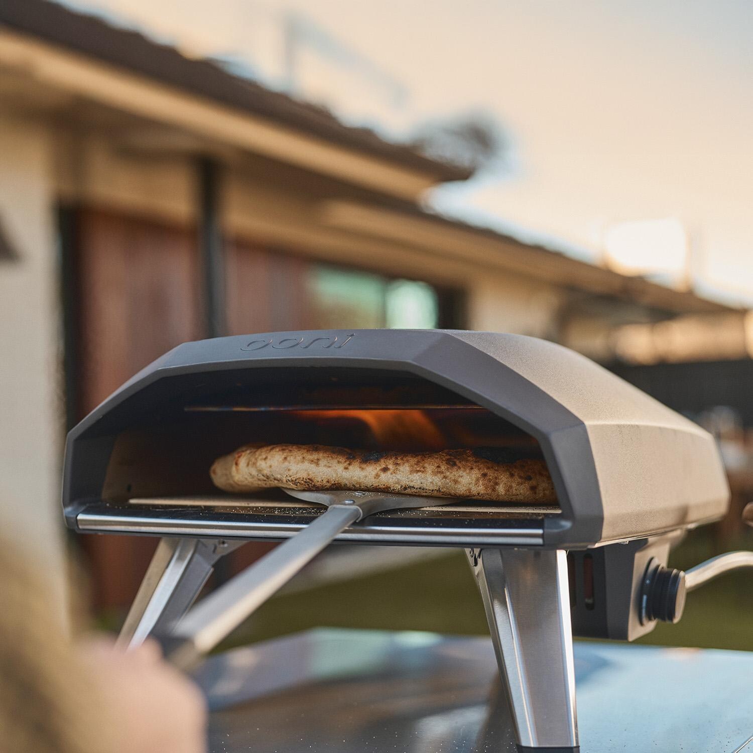 Ooni UU-P2D100 Koda 2 14 Inch Propane Portable Pizza Oven - Black - Turning Pizza - Lifestyle thumbnail