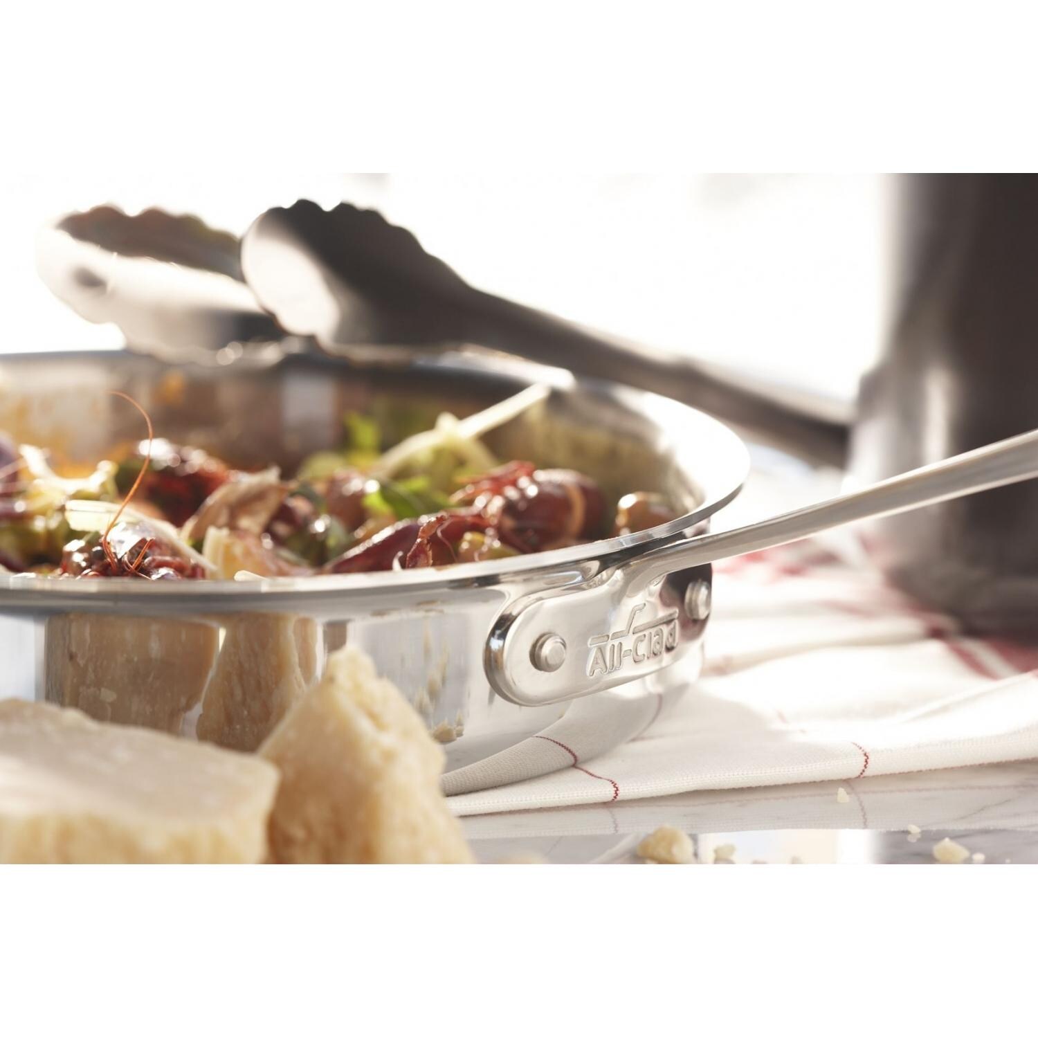 All-Clad Stainless 2-Quart Saute Pan With Loop And Lid In Use thumbnail