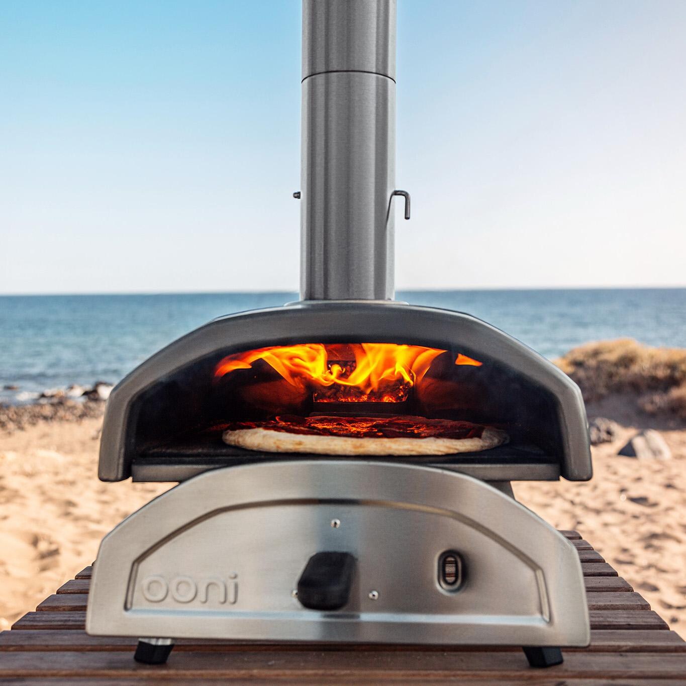 Ooni - UU-P0AD00 - Fyra 12 Wood Pellet Portable Outdoor Pizza Oven - Front View At The Beach thumbnail