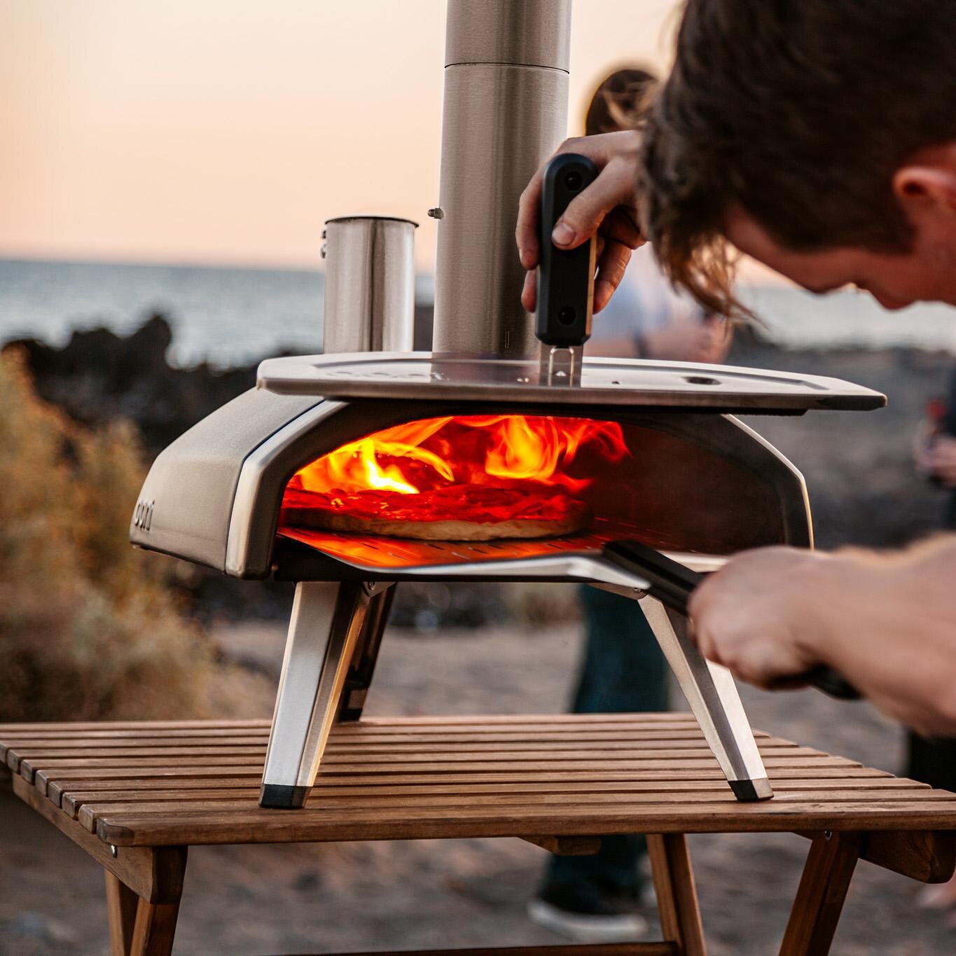 Ooni - UU-P0AD00 - Fyra 12 Wood Pellet Portable Outdoor Pizza Oven - Checking On Pizza At The Beach thumbnail