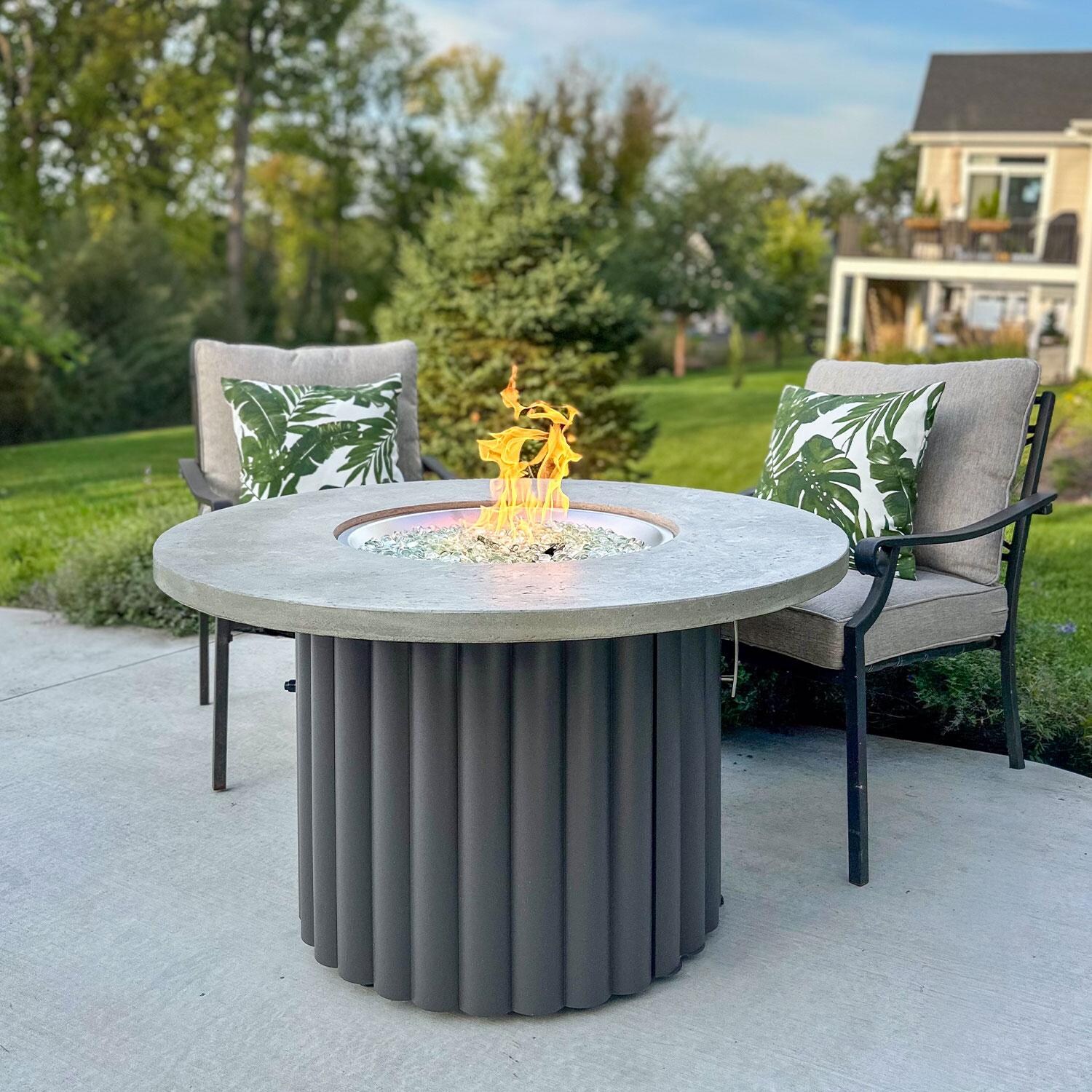 Reverie REVRCH-42-K-NG 42-in Round Aluminum Natural Gas Fire Pit Table w/ Relic Grey Supercast Top & Charcoal Base (Ships Propane w/ Conversion Kit) - Back Patio - Lifestyle thumbnail