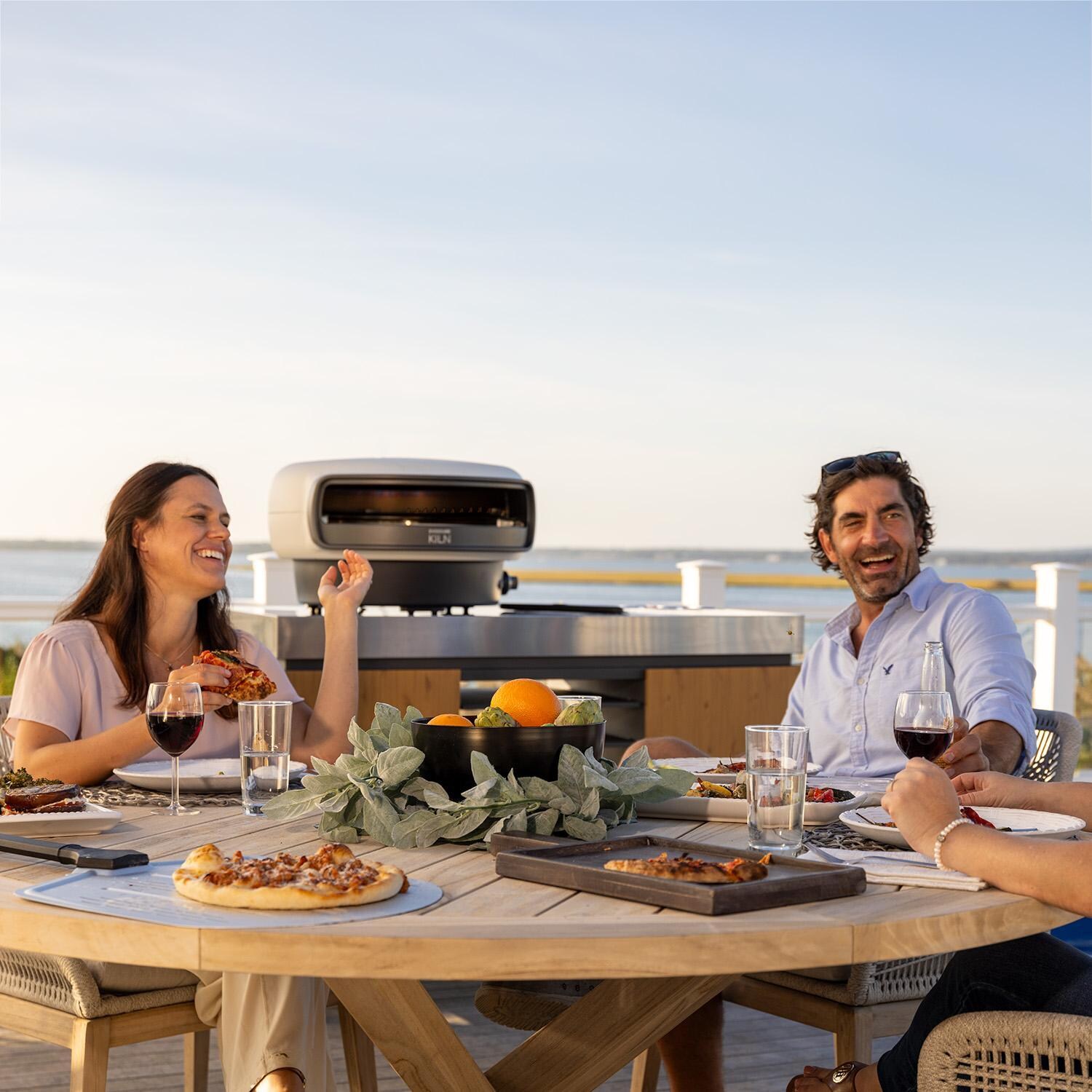 Everdure EKILN1SUS 1-Burner KILN Pizza Oven - Stone - Dinner on Patio - Lifestyle thumbnail