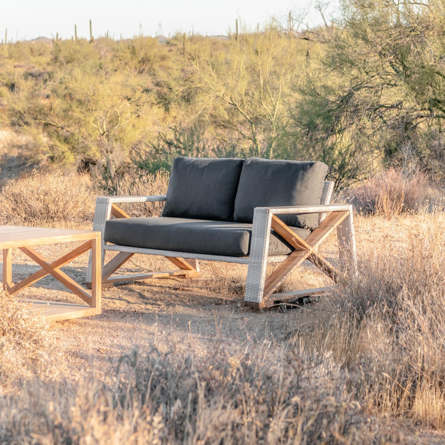 Teak + Table Caicos Loveseat in Granite - Dessert Lifestyle View (Carbon Cushions Shown) - Lifestyle thumbnail