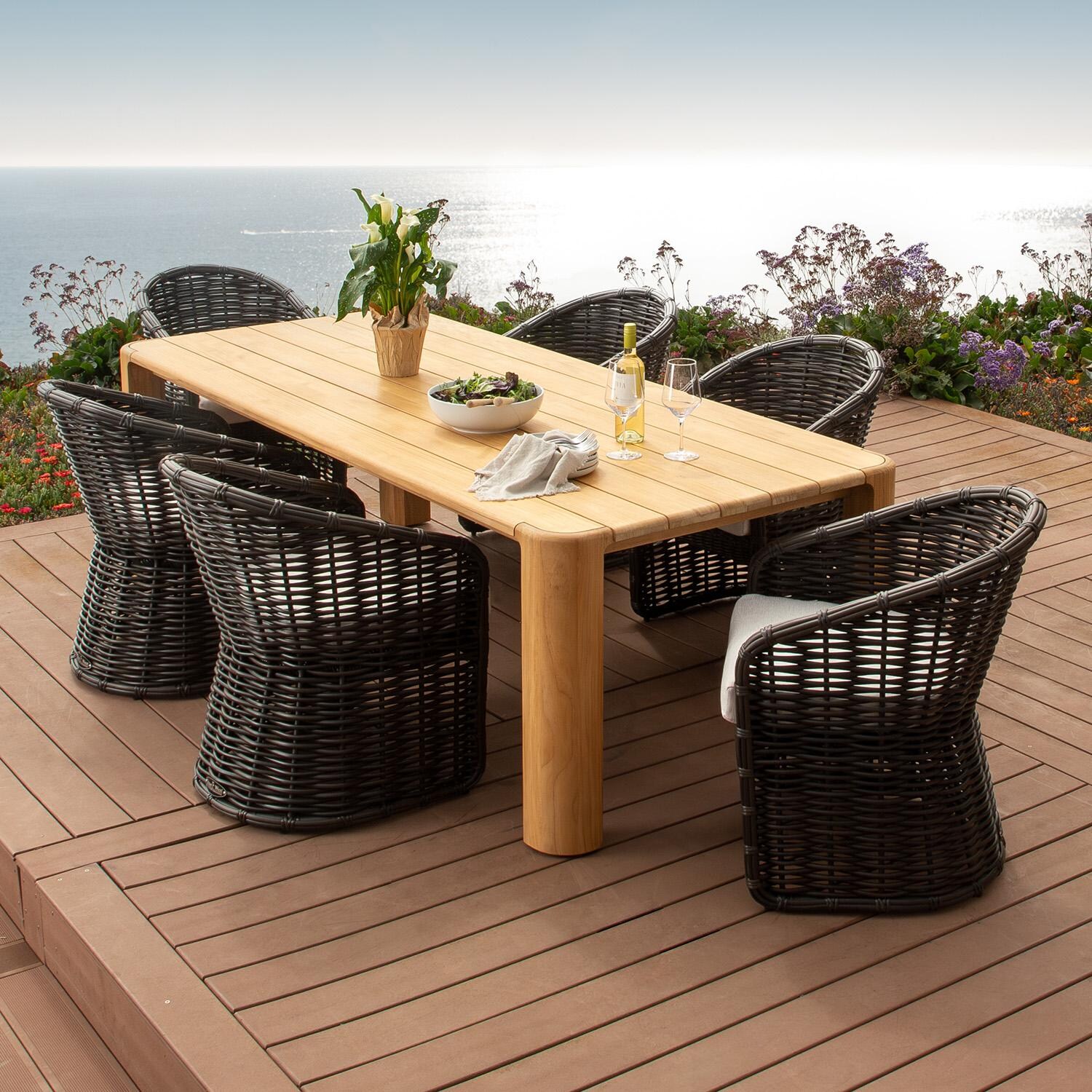 Natural Teak 96 Inch Light Wood Teak Dining Table by Sunset West - Shown as Set w/ Black Chairs - Lifestyle thumbnail