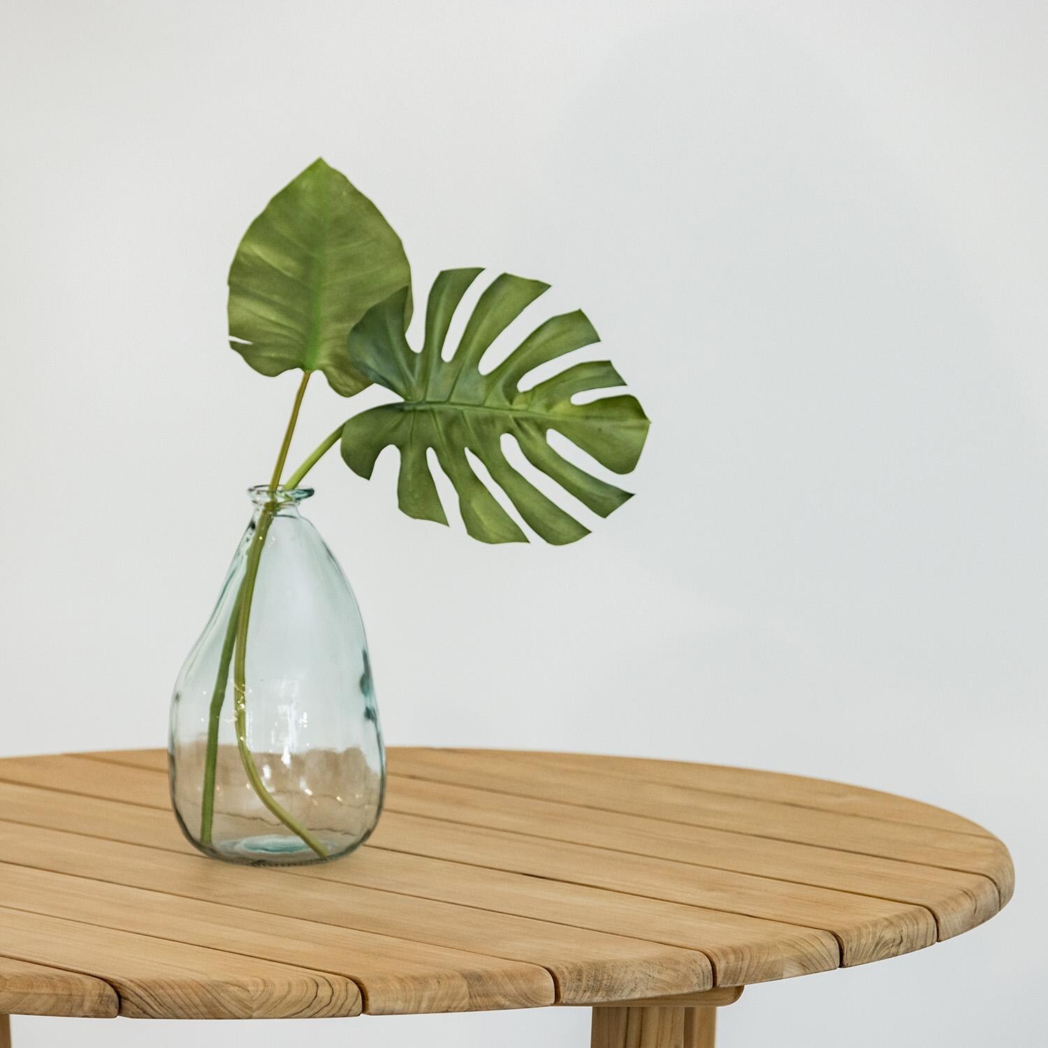 Natural Teak 56 Inch Light Wood Teak Round Dining Table by Sunset West - Table Top w/ Plant - White Background thumbnail