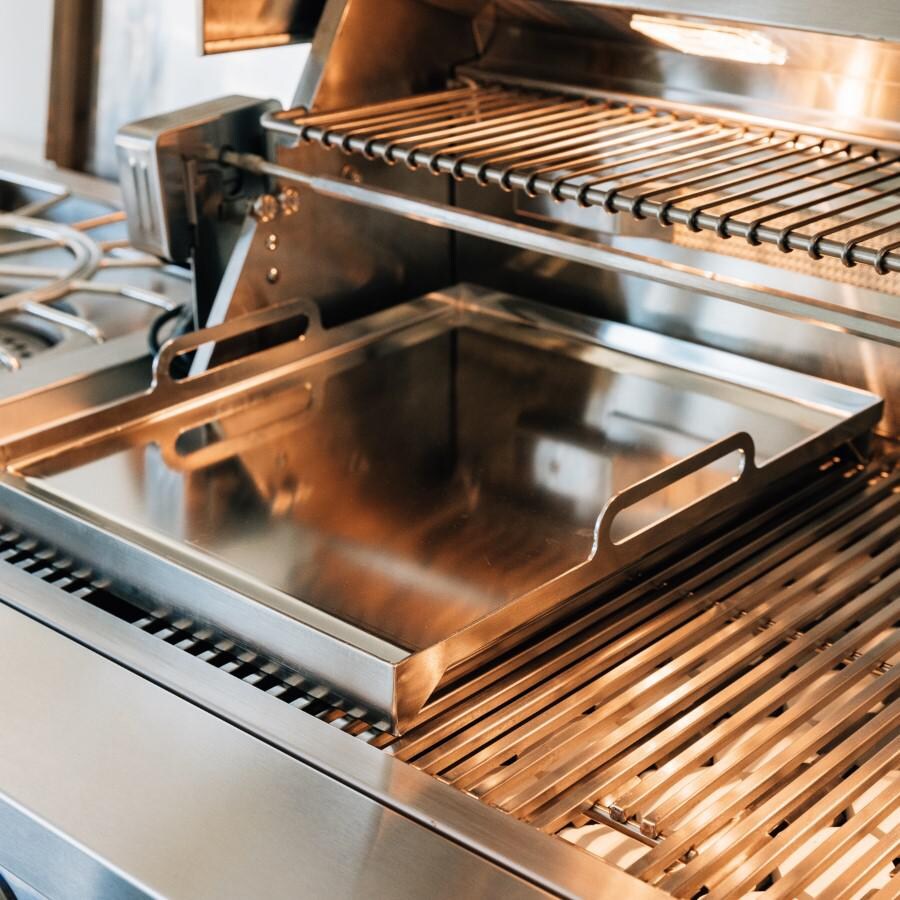 American Made Grills AMG-GP-18 14.5 x 18 Inch Griddle Plate - Angled View on Grill with Light Shining on it thumbnail