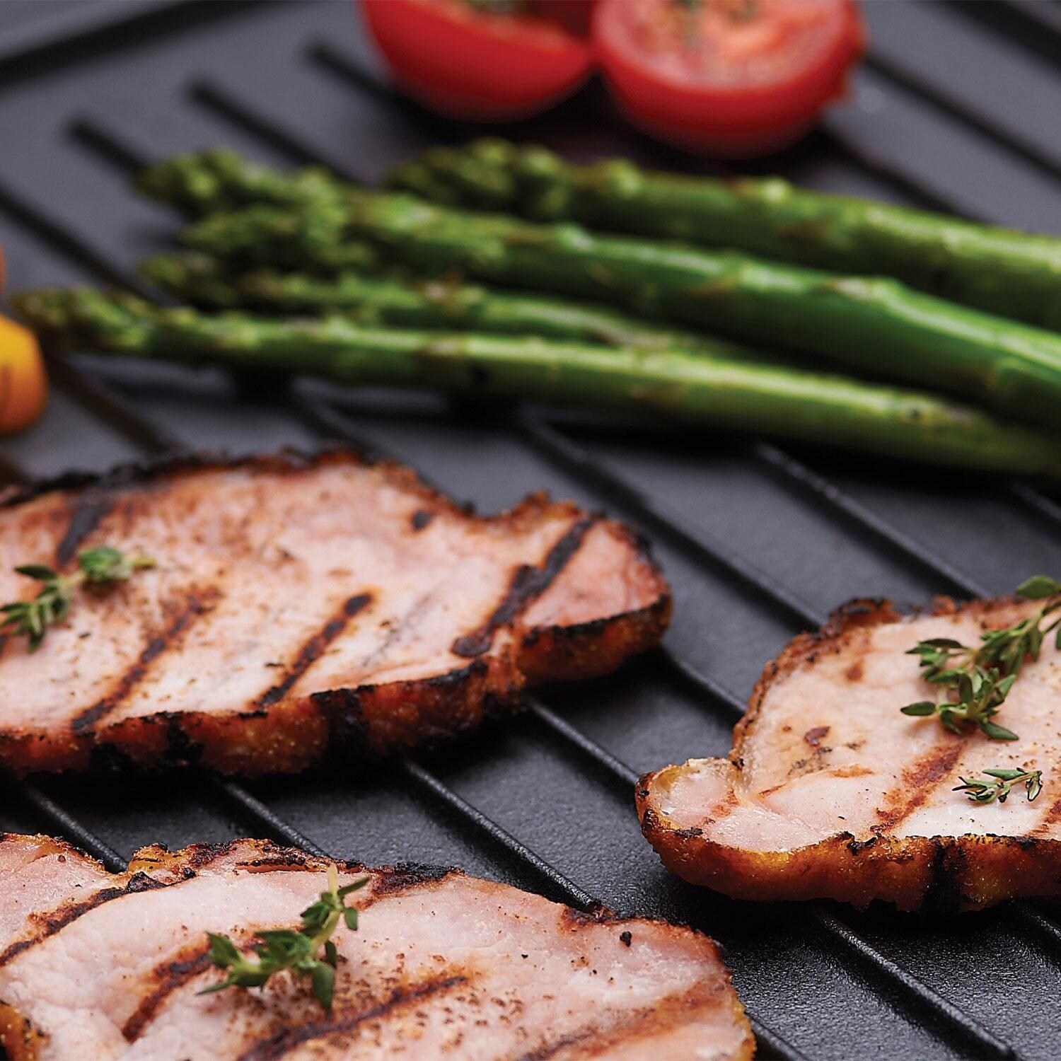 Broil King 11242 Exact Fit Cast Iron Griddle for Baron & Crown Series - Picking Up Ham w/ Tongs on Iron Griddle - Lifestyle thumbnail