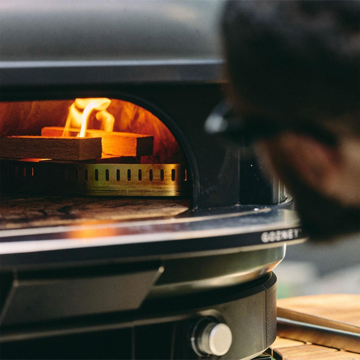 Gozney GMNOBUS1626 Off Black Dome Gen 2 Natural Gas Pizza Oven Bundle - Loading Wood - Lifestyle thumbnail