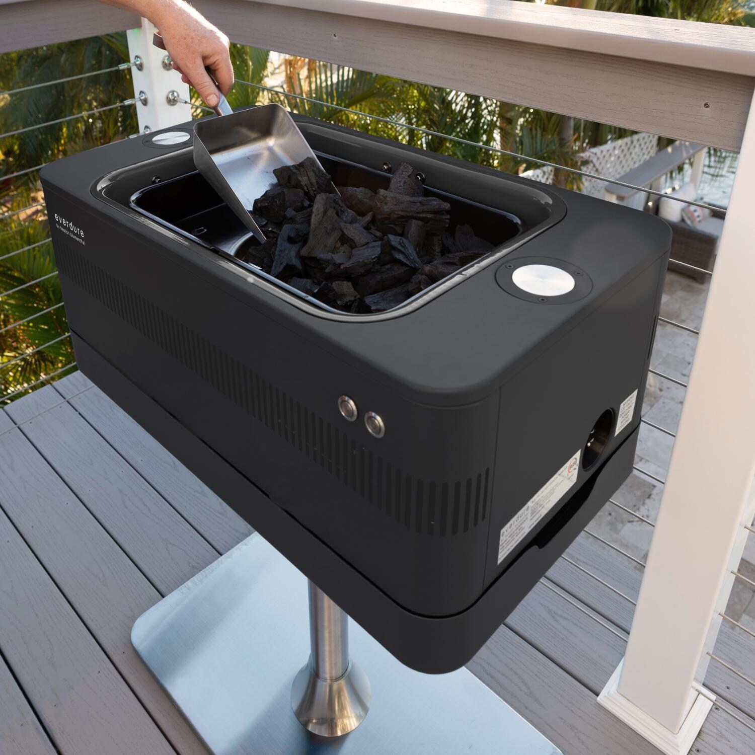 Everdure HBCE1BBSUS FUSION 29-Inch Charcoal Grill w/ Rotisserie & Electronic Ignition - Matte Black - Filling w/ Charcoal - Lifestyle thumbnail