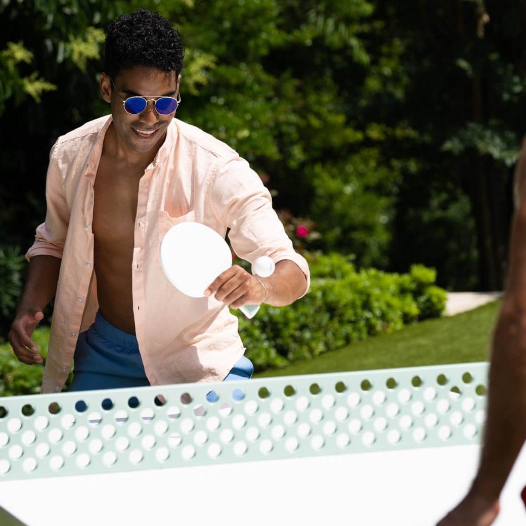 Ledge Lounger Ping Pong Table - White w/ Sage Green Net & Paddle Accent - Returning a Serve - Lifestyle thumbnail