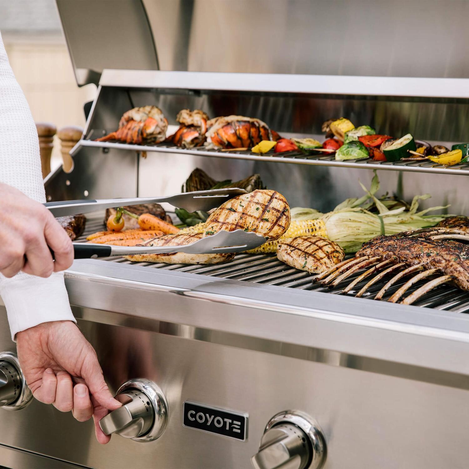 Coyote RTAC-G6-SW-C2C34LP Ready-To-Assemble 6 Ft Outdoor Kitchen Island With 34-Inch C-Series Propane Gas Grill - Stacked Stone/Modern White - Lifestyle View Close Up Grilling Angle thumbnail