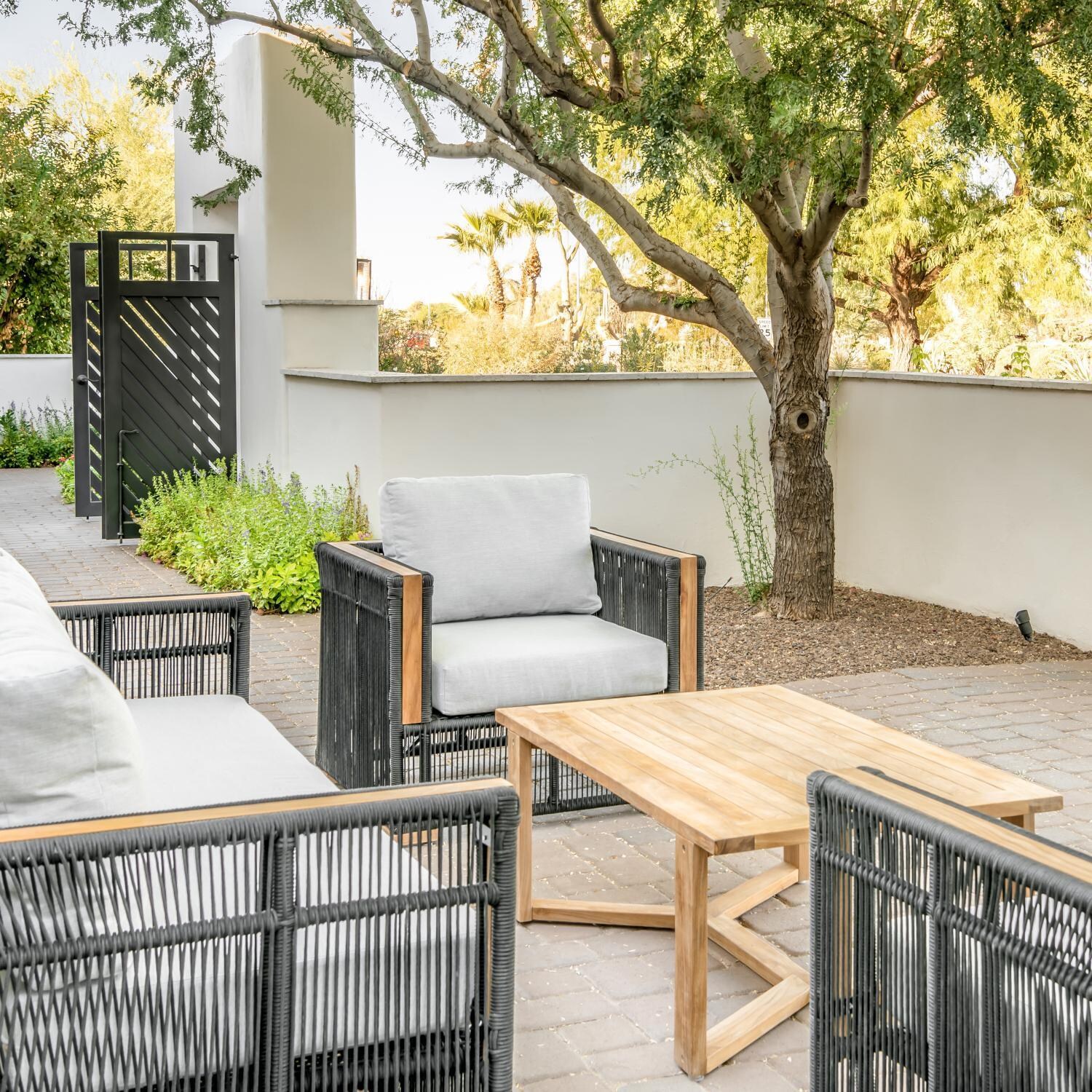 Teak + Table Breeze Olefin Rope & Teak Patio Club Chair in Charcoal/Granite - On Patio - Lifestyle thumbnail