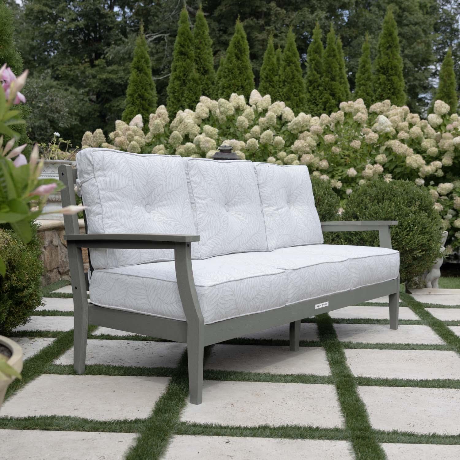 Blushing Bay 3 Person Recycled Plastic Sofa in Lively Parchment/Coastal Teak by Lakeview Outdoor Designs - Side View - Lifestyle thumbnail
