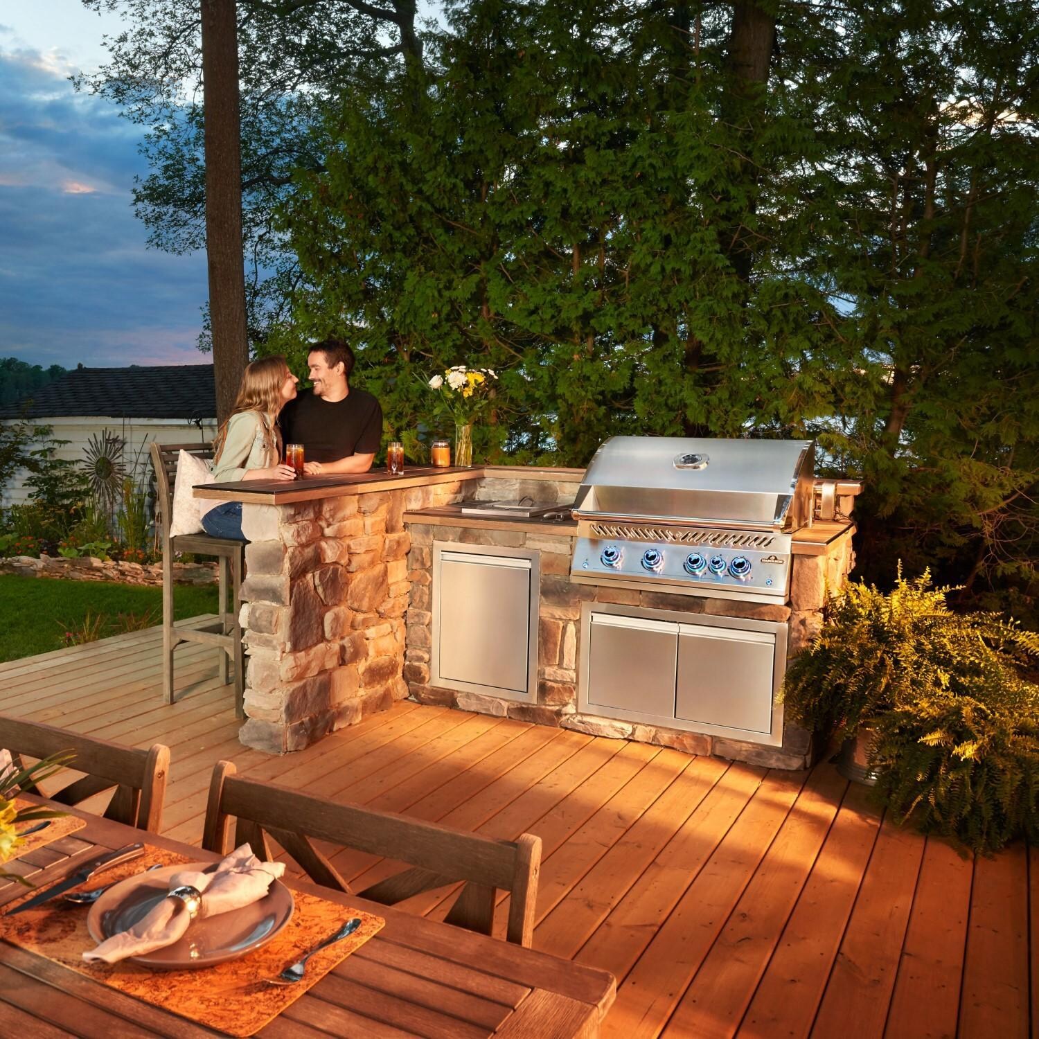 Napoleon BIG32RBNSS-1 Natural Gas Grill - Couple Sitting at Bar by Built-In Grill - Lifestyle thumbnail