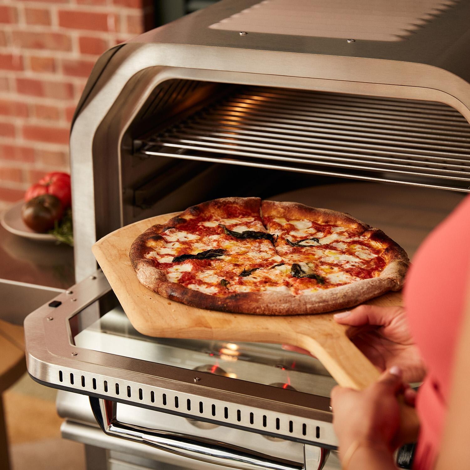Blaze BLZ-26-PZOVN-NG 26-Inch Built-In Natural Gas Outdoor Oven W/ Rotisserie - Taking Pizza Out of Oven - Detail thumbnail