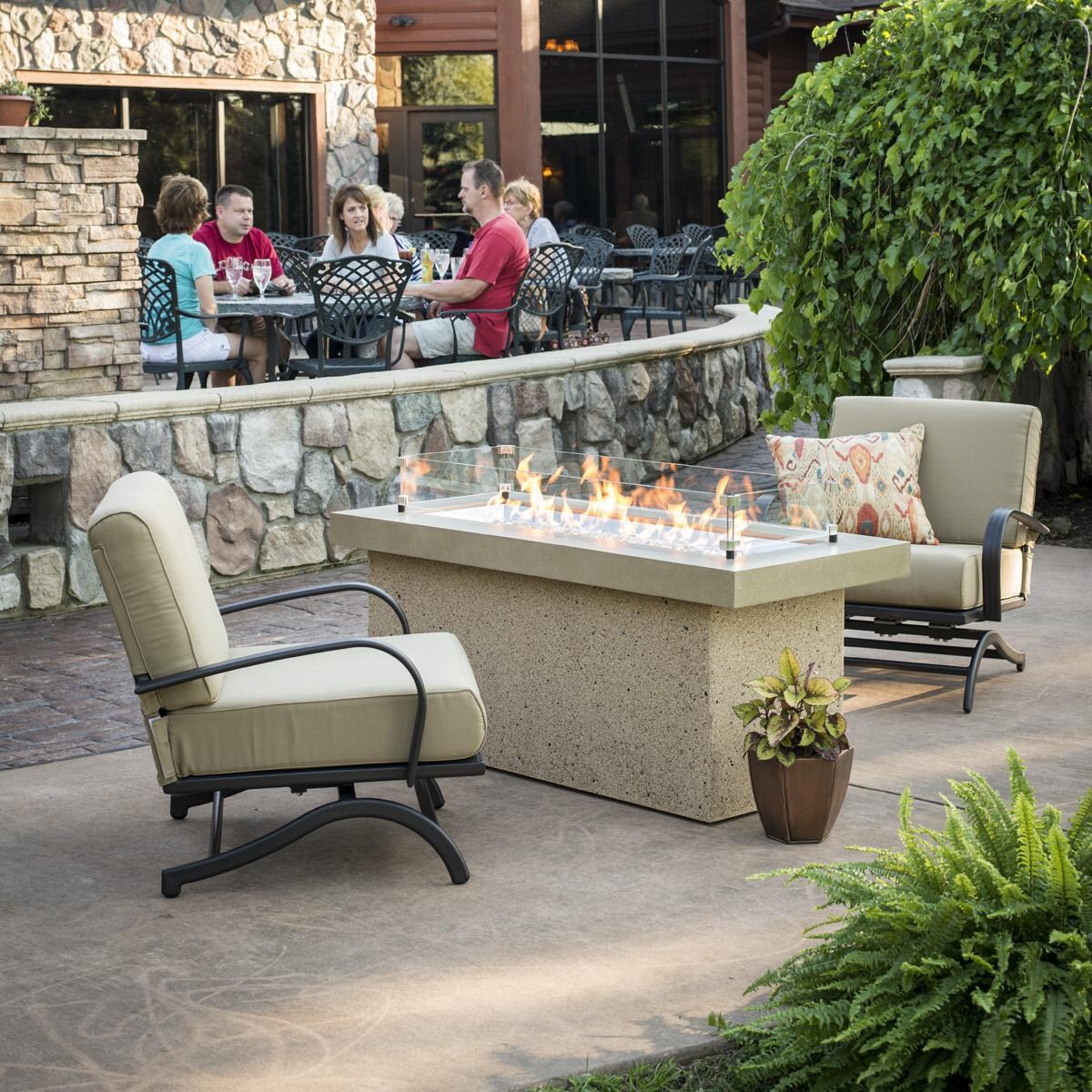 The Outdoor GreatRoom Company Key Largo Linear Gas Fire Pit Table - Brown - Lifestyle - Glass wind guard pictured is optional accessory thumbnail