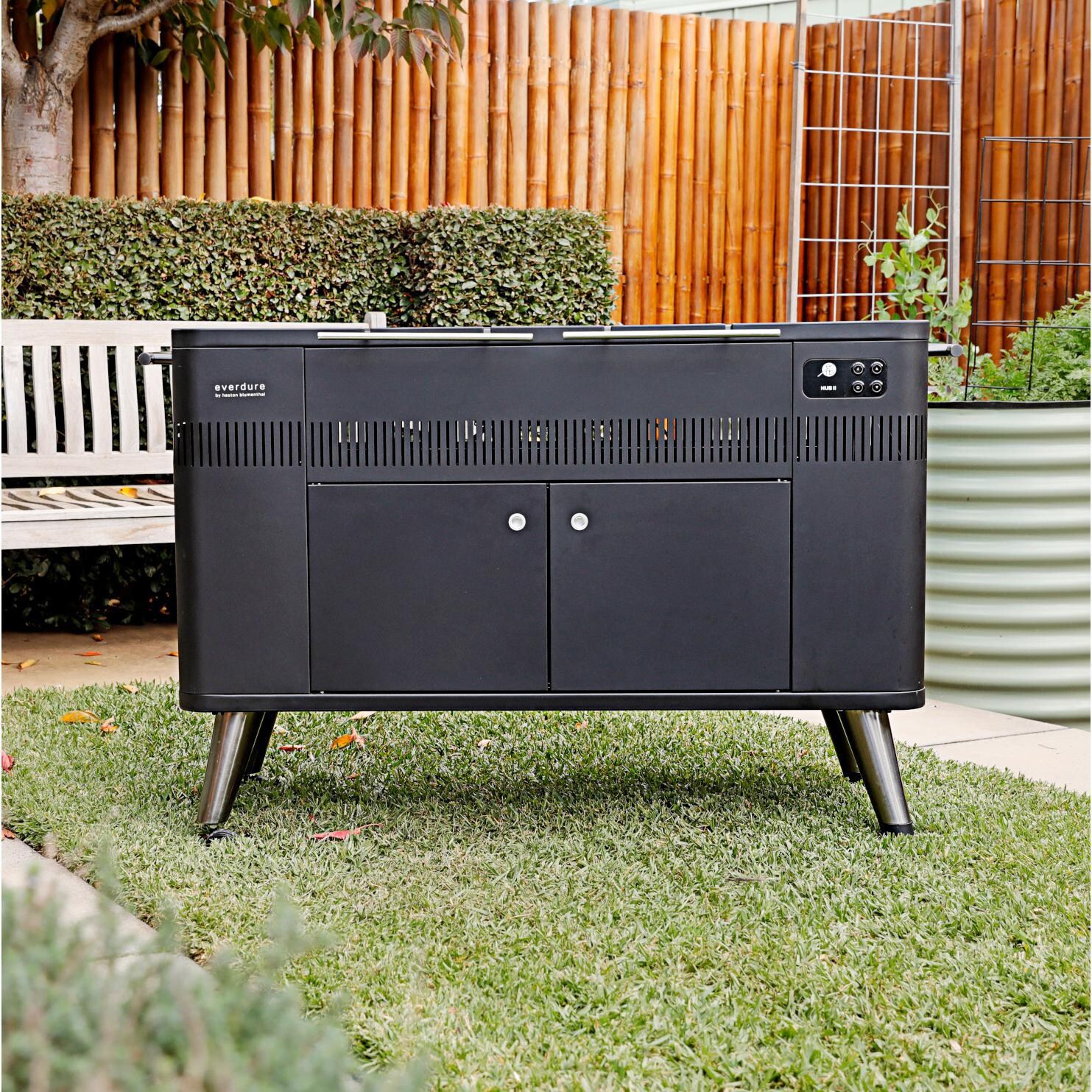 Everdure HBCE3BUS HUB II 54-Inch Charcoal Grill With Rotisserie & Electronic Ignition - In the Backyard - Front View thumbnail
