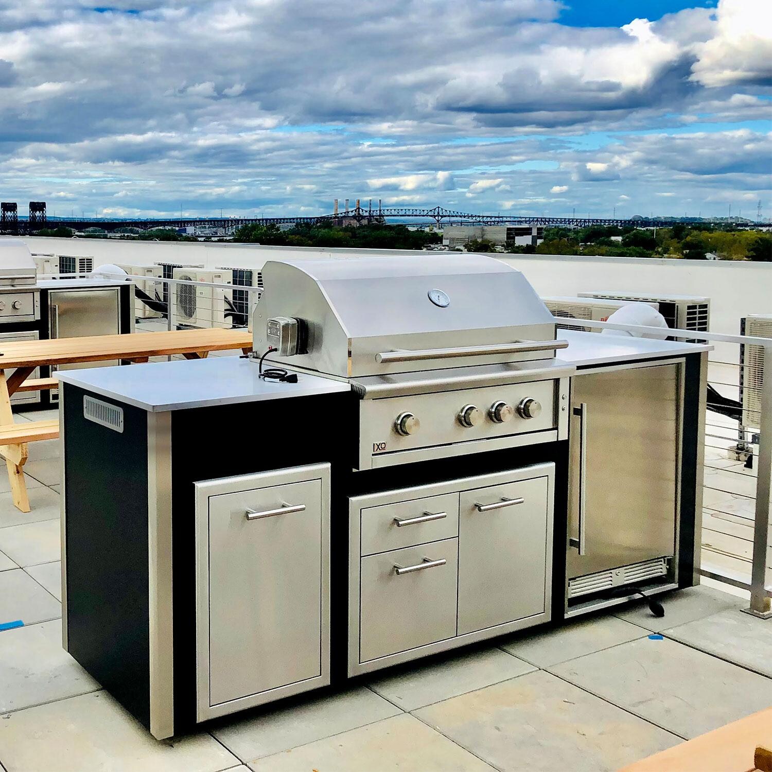 XO Designer 8 1/2 Ft Outdoor Kitchen Island w/ 36-in Natural Gas Pro-Grade Grill, Door & Drawer, Trash Drawer & Outdoor Refrigerator in White - Shown in Black finish - Lifestyle thumbnail