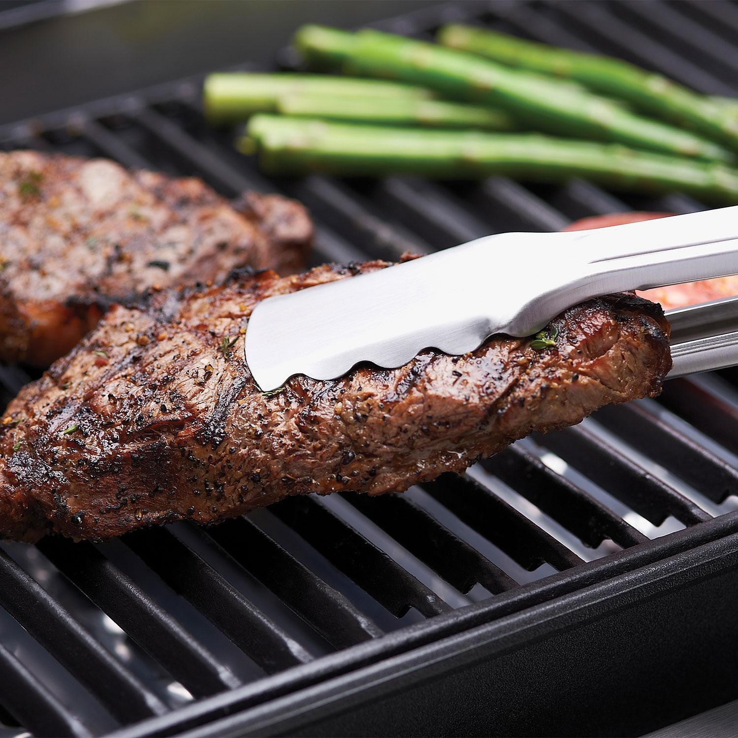 Broil King 11228 2 Pc Cast Iron Cooking Grids for Signet Series - Taking Steaks off Grid W/ Tongs - Lifestyle thumbnail