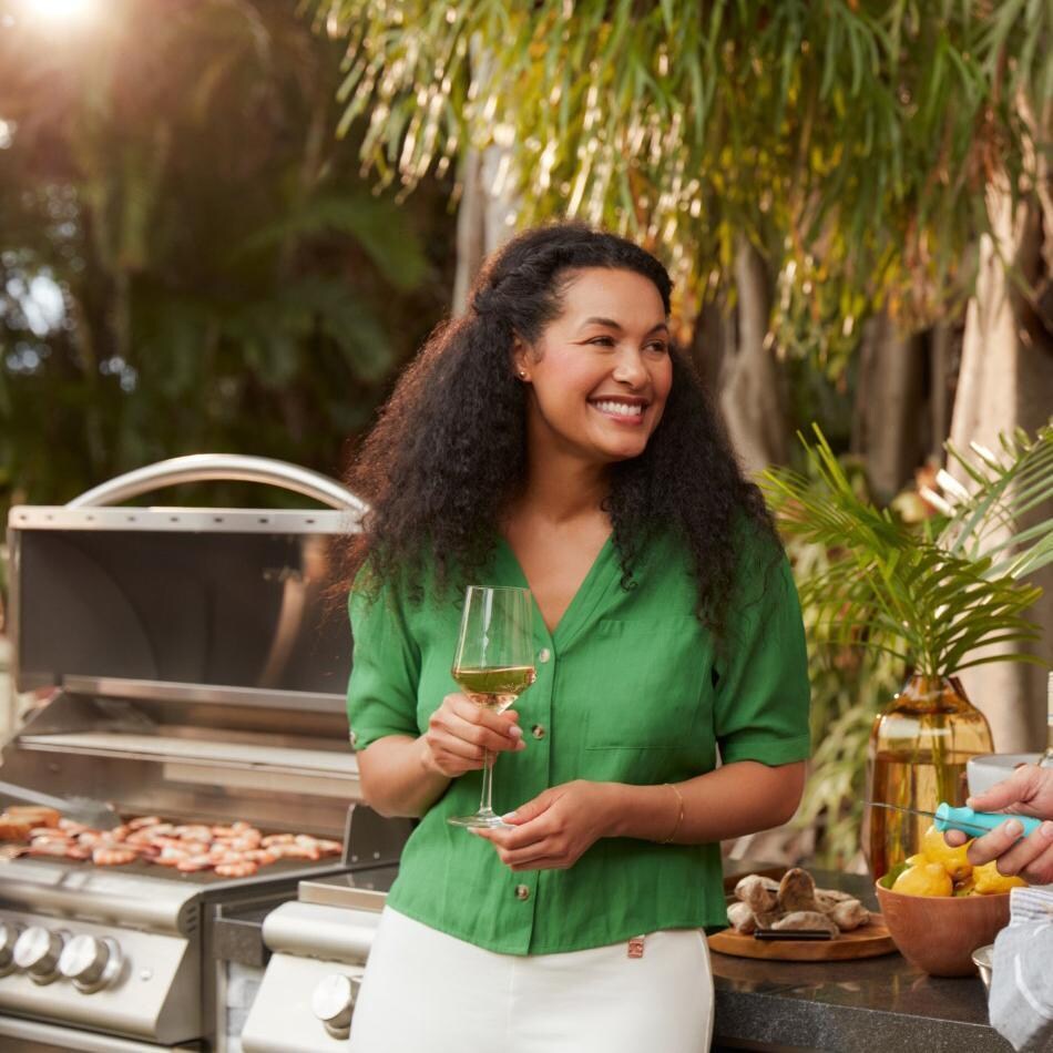 Blaze BLZ-4LTE3MG-LP Premium LTE + Marine Grade 32-Inch 4-Burner Built-In Propane Grill With Rear Infrared Burner & Lift-Assist Hood - Couple Standing By Grill - Lifestyle thumbnail