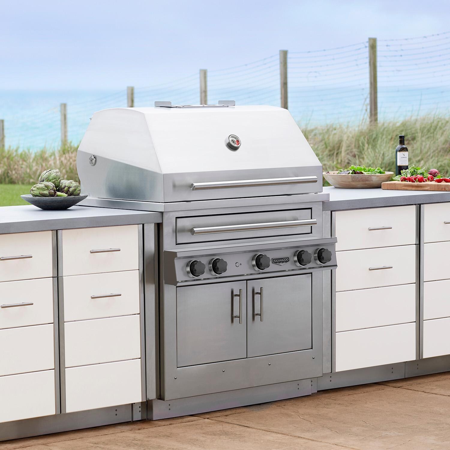 Kalamazoo K750HB Hybrid Fire Three Burner Marine Grade Built-In Natural Gas Grill W/ Two Plancha Surface Grates - Shown in Outdoor Kitchen - Lifestyle thumbnail