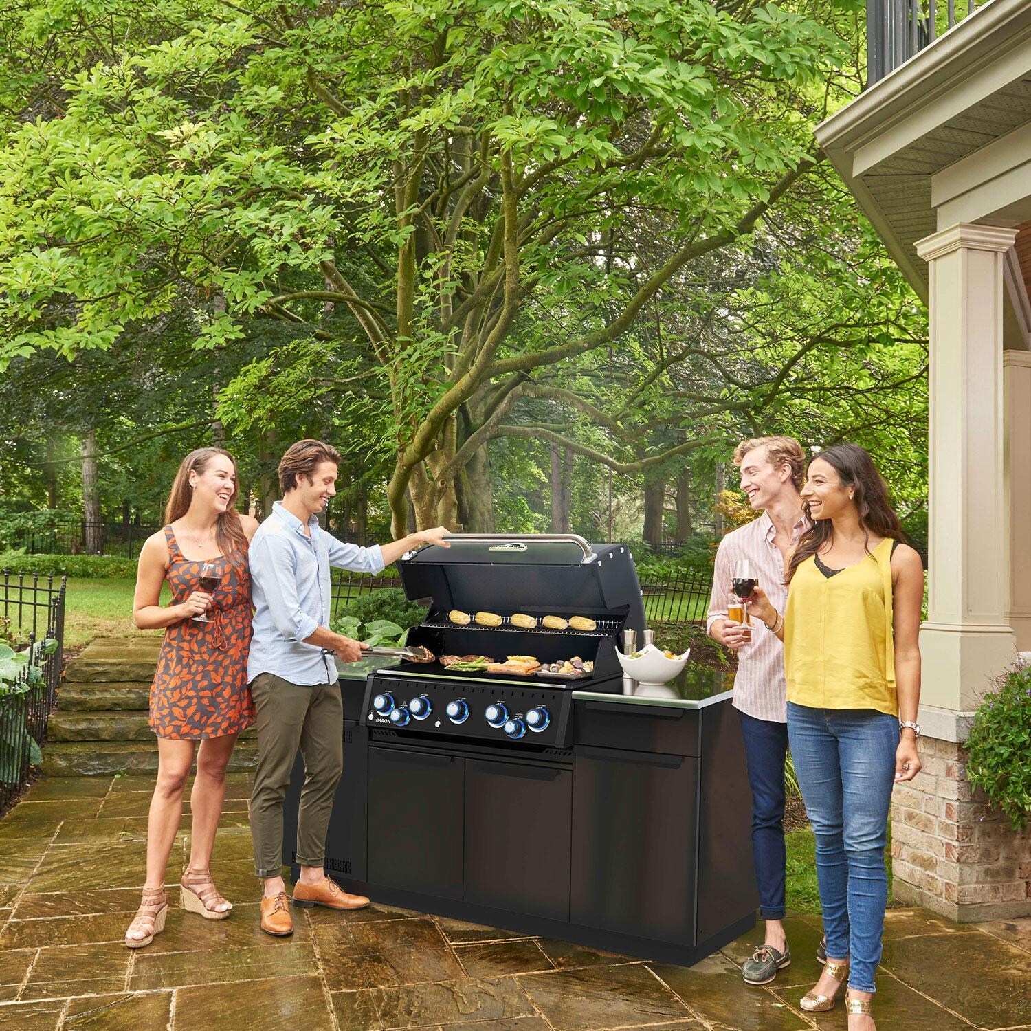 Broil King 876847 Baron 590i Shadow 5 Burner Natural Gas Grill Center w/ Rotisserie & Side Burner - Grilling w/ Friends & Side Shelf In Use - Lifestyle thumbnail