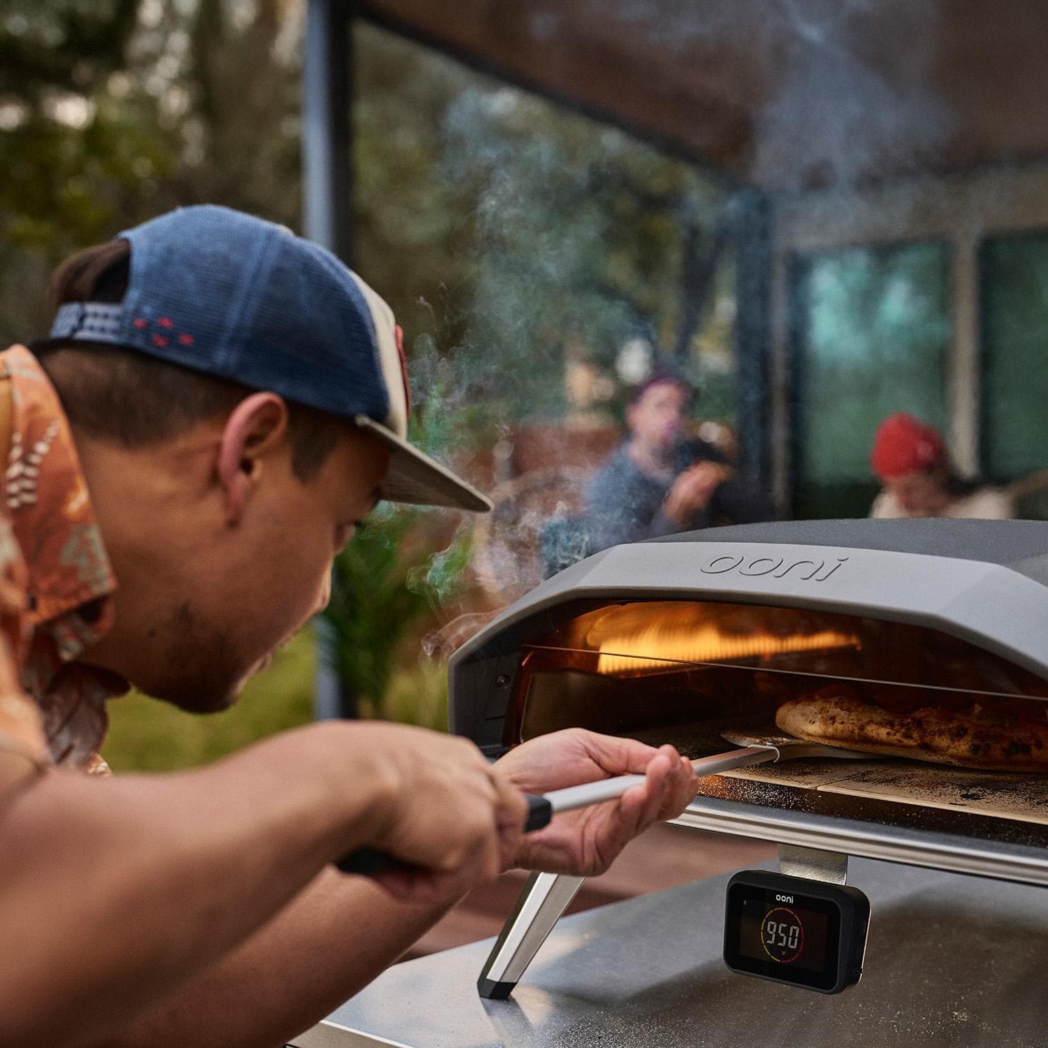 Ooni UU-P33A00 Koda 2 Pro 18 Inch Propane Portable Pizza Oven - Blue - Turning Pizza (Shown in Black) - Lifestyle thumbnail