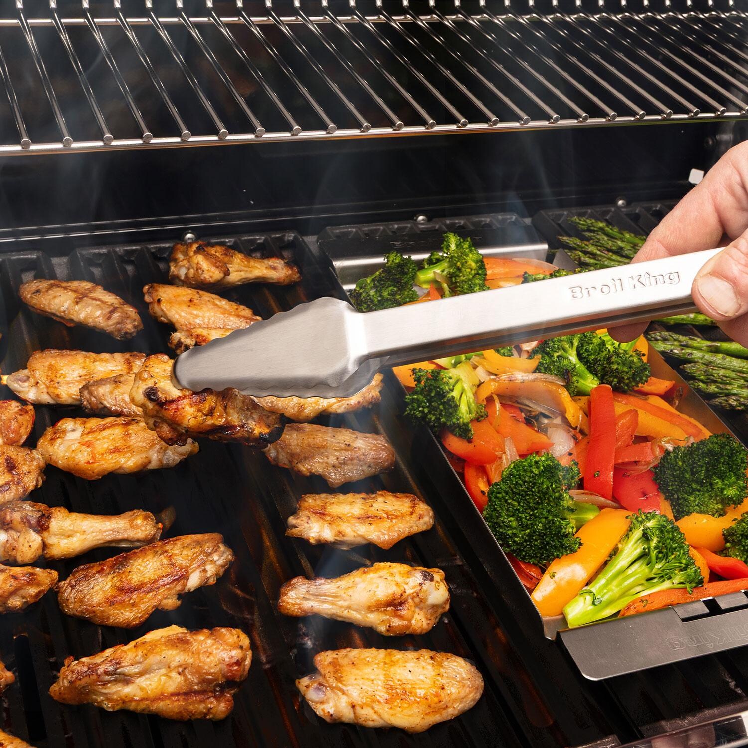 Broil King 64046 Ultra Lite 12-in Stainless Steel Tongs - Flipping Chicken - Lifestyle thumbnail