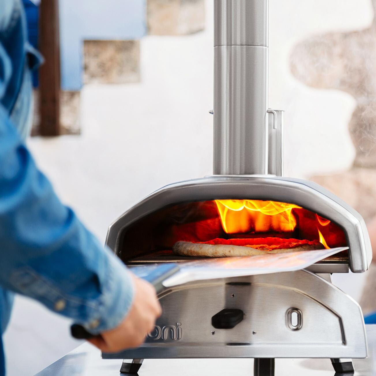 Ooni - UU-P0AD00 - Fyra 12 Wood Pellet Portable Outdoor Pizza Oven - Taking Out A Pizza thumbnail