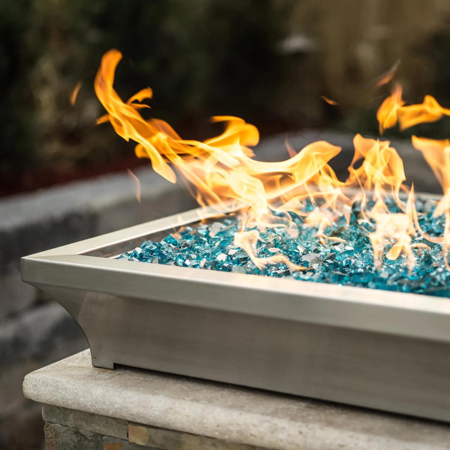 BBQGuys Signature ALP-FBL-LAV-SS-24-L Lavelle 24-Inch Square Low-Rise Natural Gas Column Fire Bowl - Stainless Steel - Lifestyle - Shown with 1/2 Inch Caribbean Blue Reflective Fire Glass thumbnail