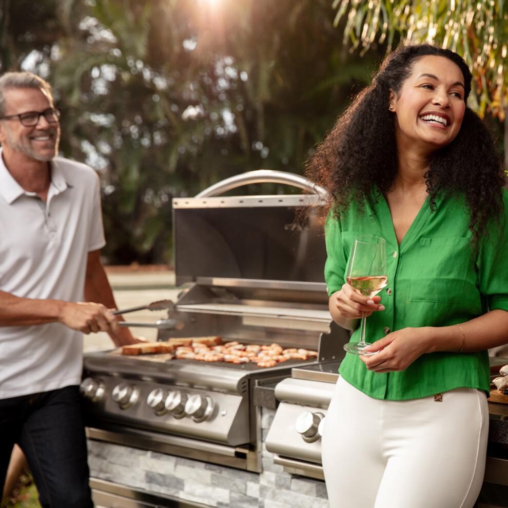 BBQGuys Signature 8 Ft Outdoor Kitchen Island w/ Blaze Premium LTE+ 32-Inch Natural Gas Grill, Premium LTE+ Power Burner, 24-Inch Beverage Cooler - Alaska Gray Stone w/ American Black Polished Granite - Cooking on Grill 2 - Lifestyle thumbnail