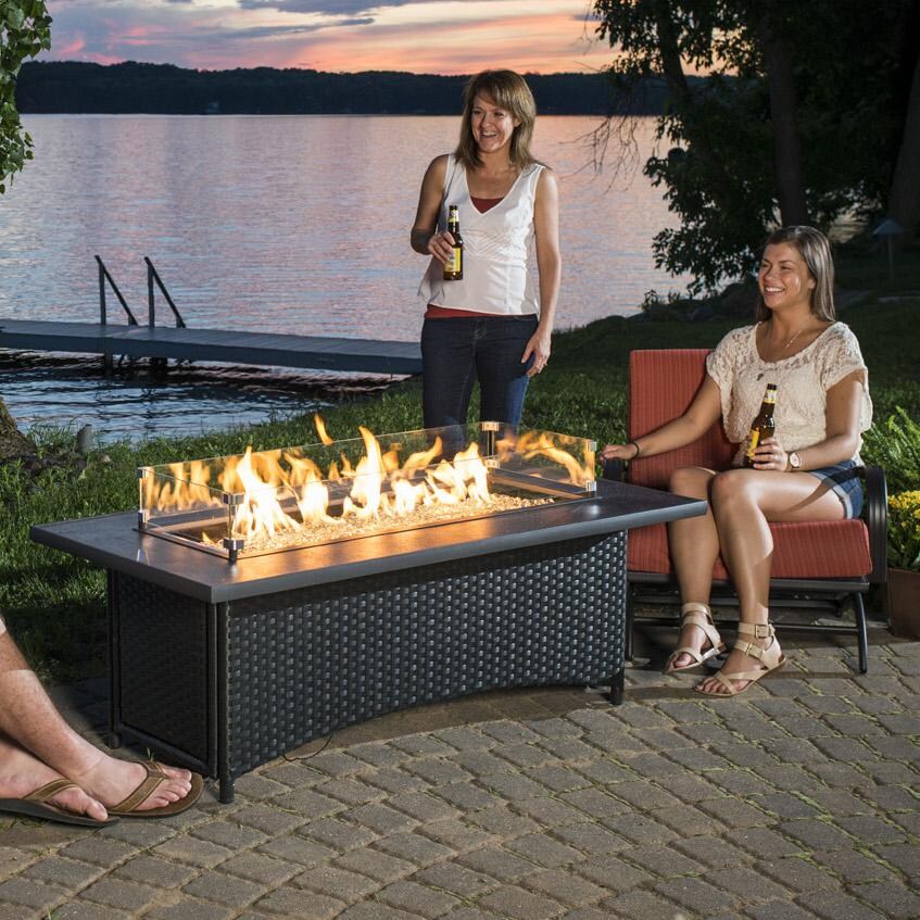 The Outdoor GreatRoom Company Montego Linear Gas Fire Pit Table - Absolute Black - Lifestyle - Glass wind guard pictured is optional accessory thumbnail