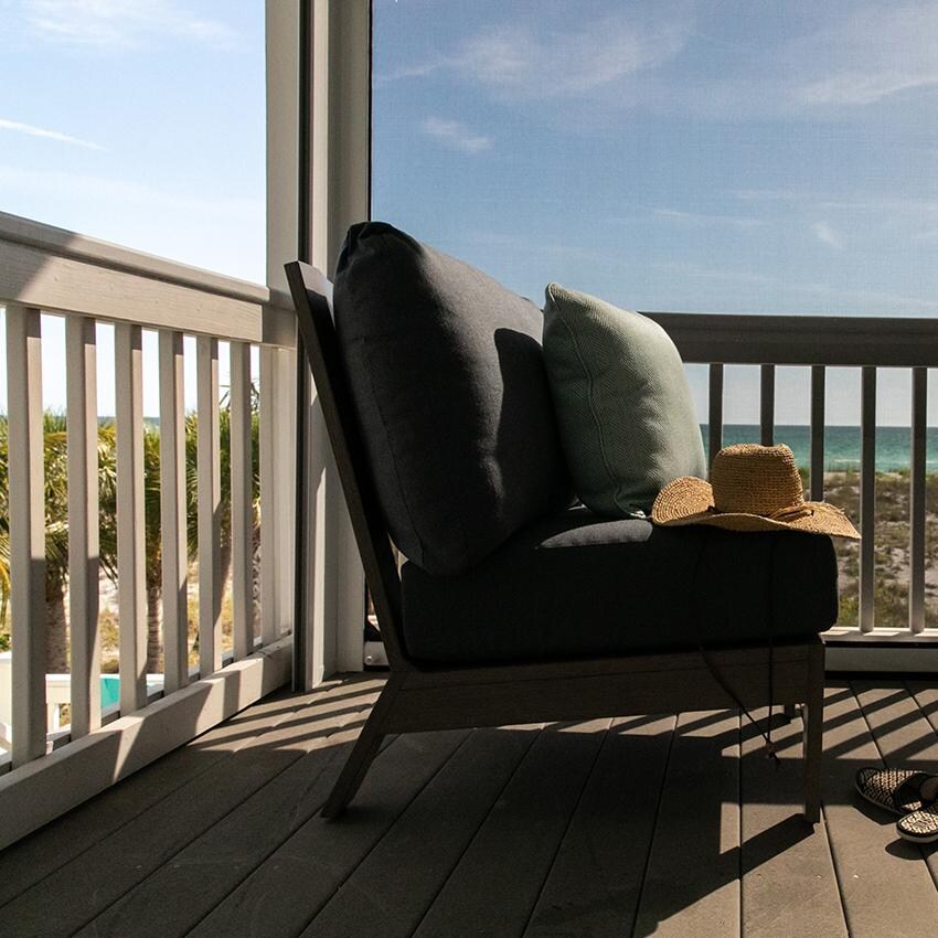 Laguna Aluminum Armless Club Chair w/ No Welt in Driftwood/Canvas Natural by Sunset West - Shown on Porch From Side - Lifestyle thumbnail