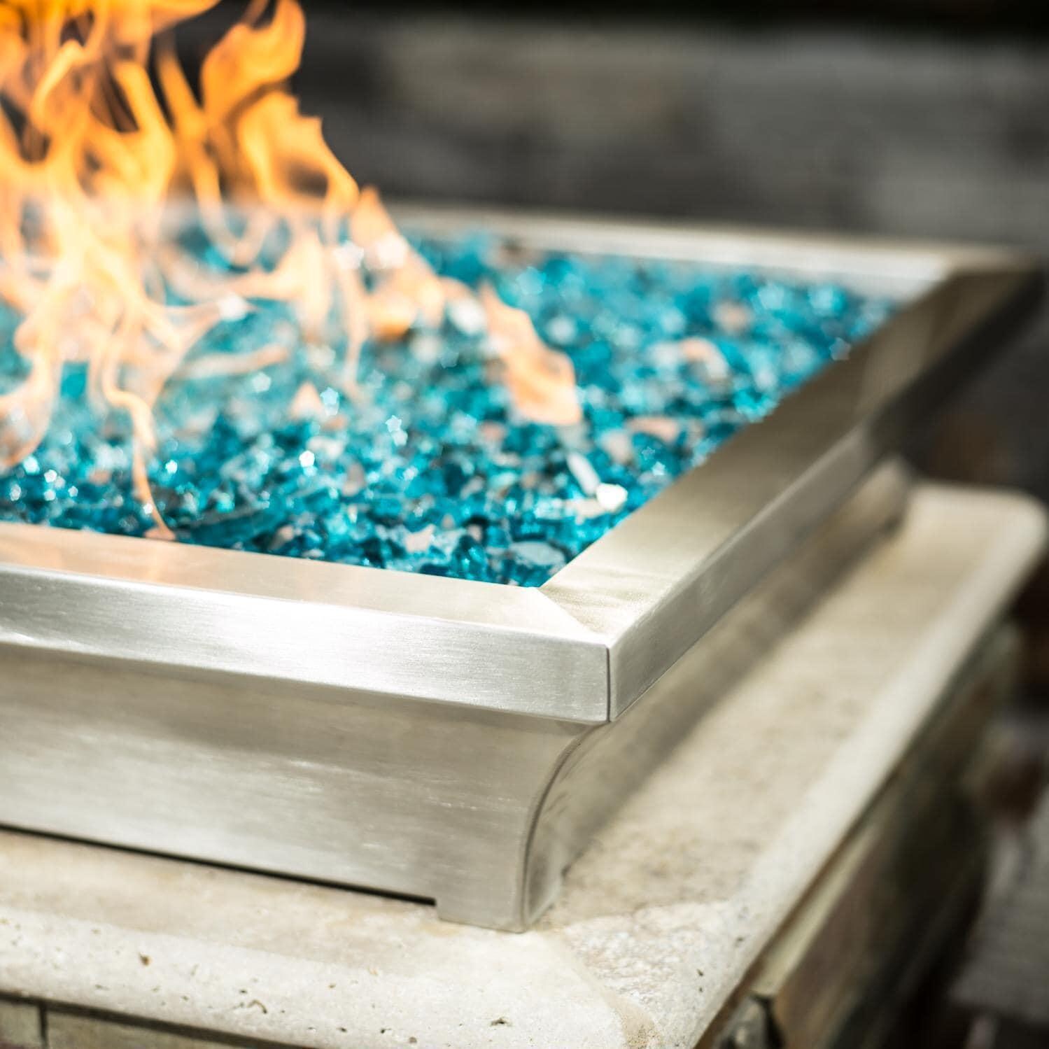 BBQGuys Signature ALP-FBL-LAV-SS-24-L Lavelle 24-Inch Square Low-Rise Natural Gas Column Fire Bowl - Stainless Steel - Lifestyle - Shown with 1/2 Inch Caribbean Blue Reflective Fire Glass thumbnail