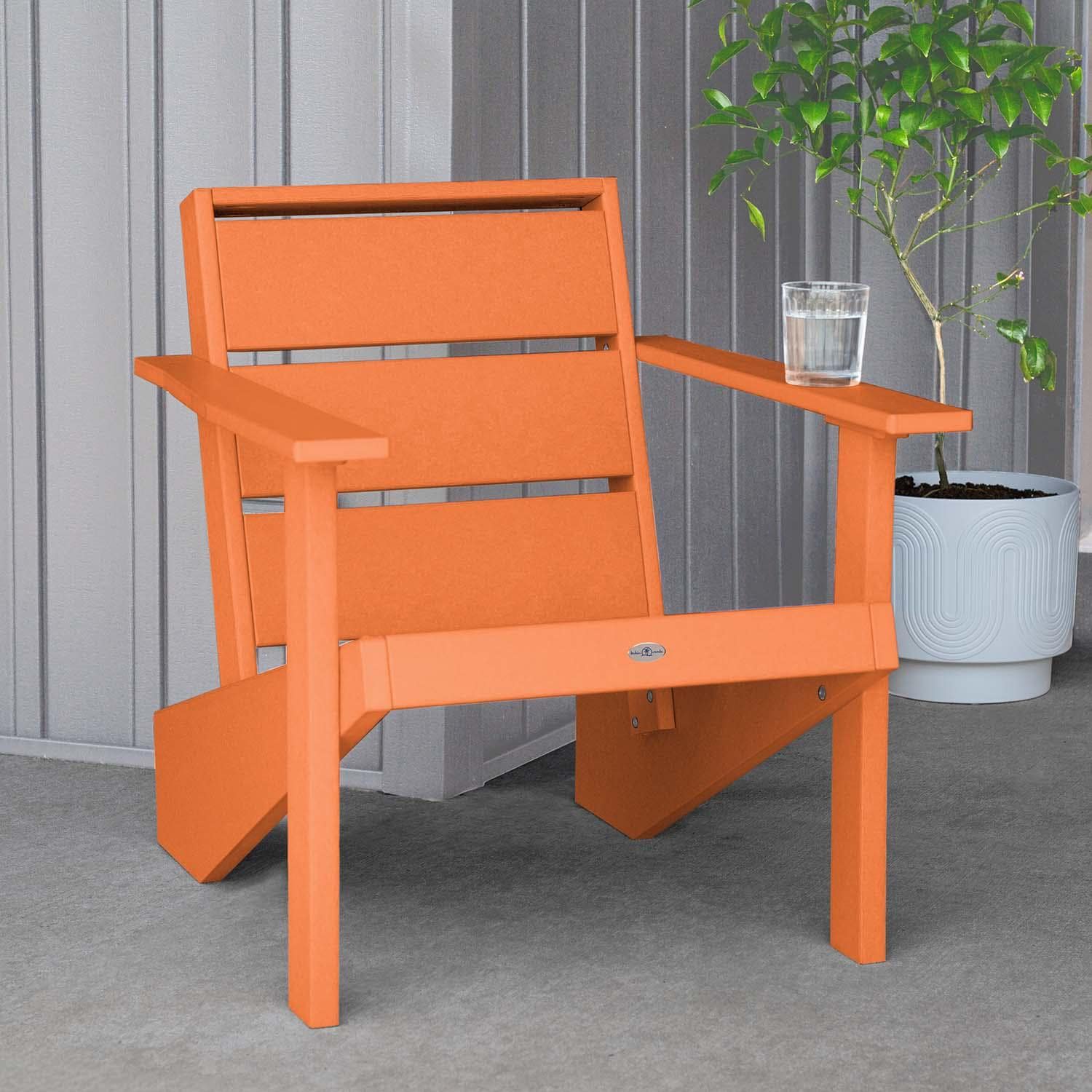 Hazel Cove Recycled Plastic Adirondack Chair in Citrus Orange by Lakeview Outdoor Designs - Next to Flowerpot - Lifestyle thumbnail