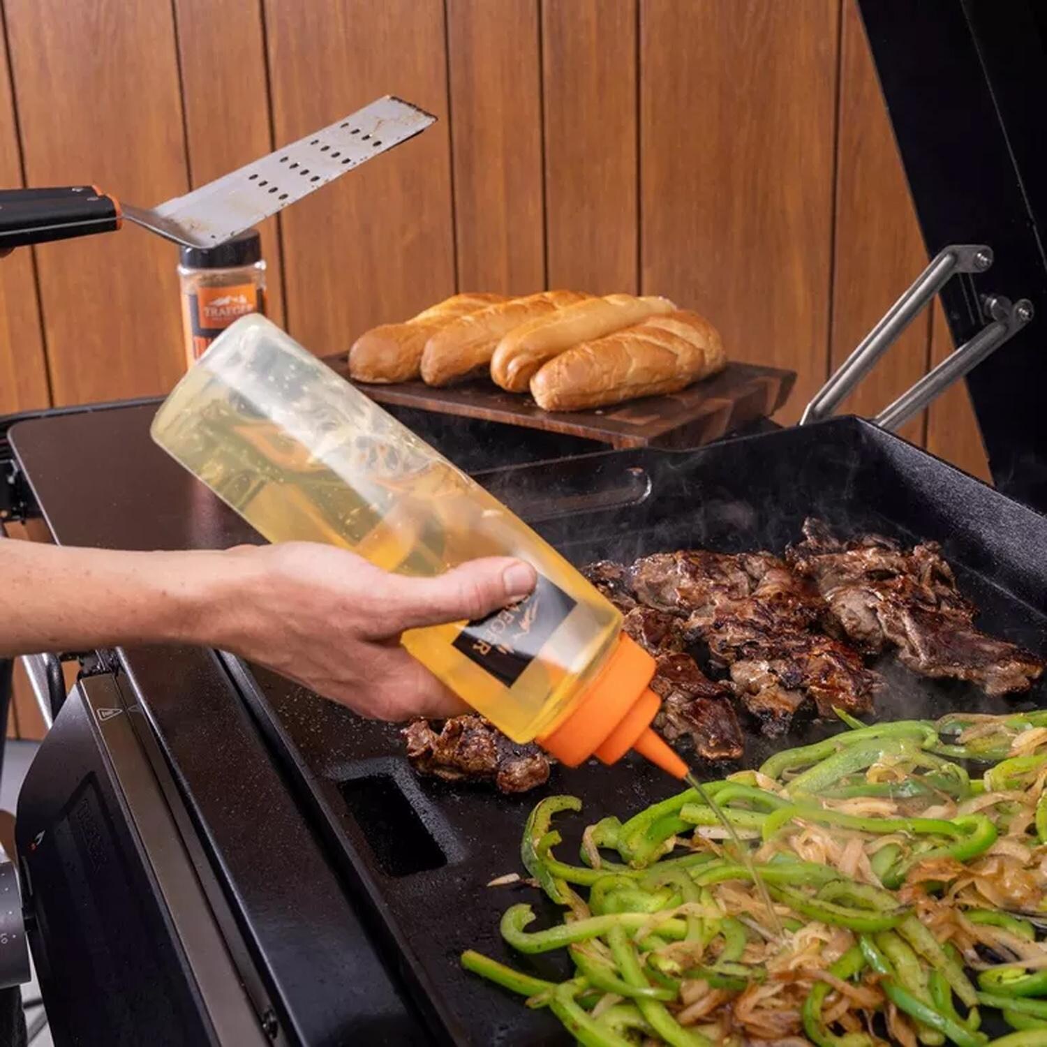 Traeger Flatrock 2 Zone Propane Griddle 4 Pc Bundle - Squeezing - Lifestyle thumbnail