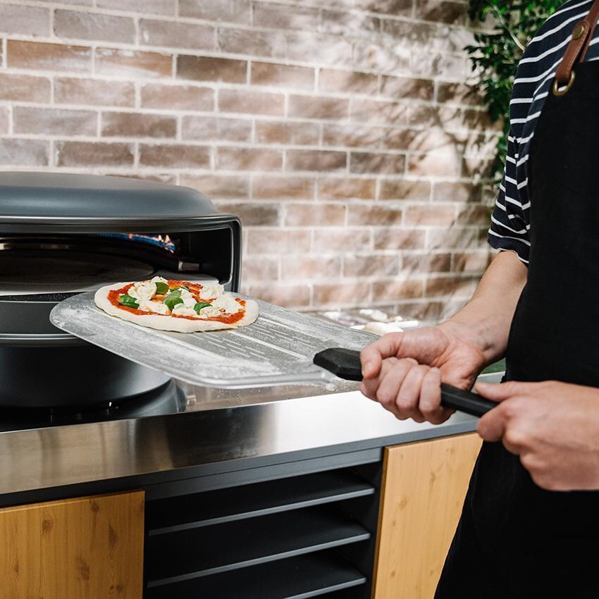 Everdure EPPEEL14 14-Inch Pizza Peel - Pizza Going in Oven - Lifestyle thumbnail