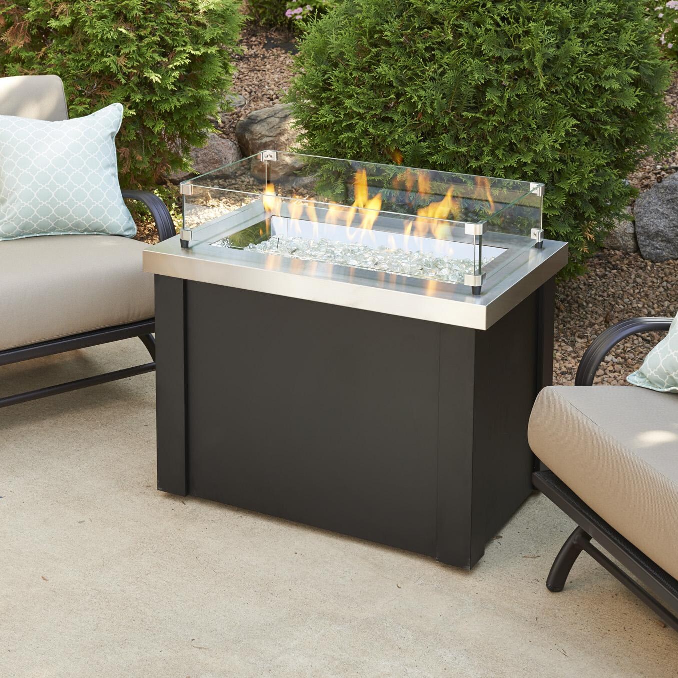 The Outdoor GreatRoom Company Providence Rectangular Gas Fire Pit Table - Stainless Steel - Lifestyle - Glass wind guard pictured is optional accessory thumbnail