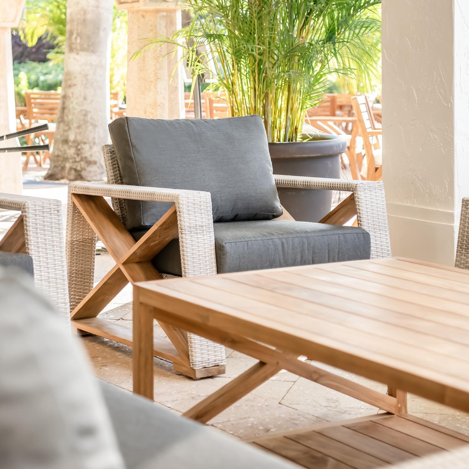 Teak + Table Caicos Club Chair in Granite - Lifestyle View (Carbon Cushions Shown) - Lifestyle thumbnail