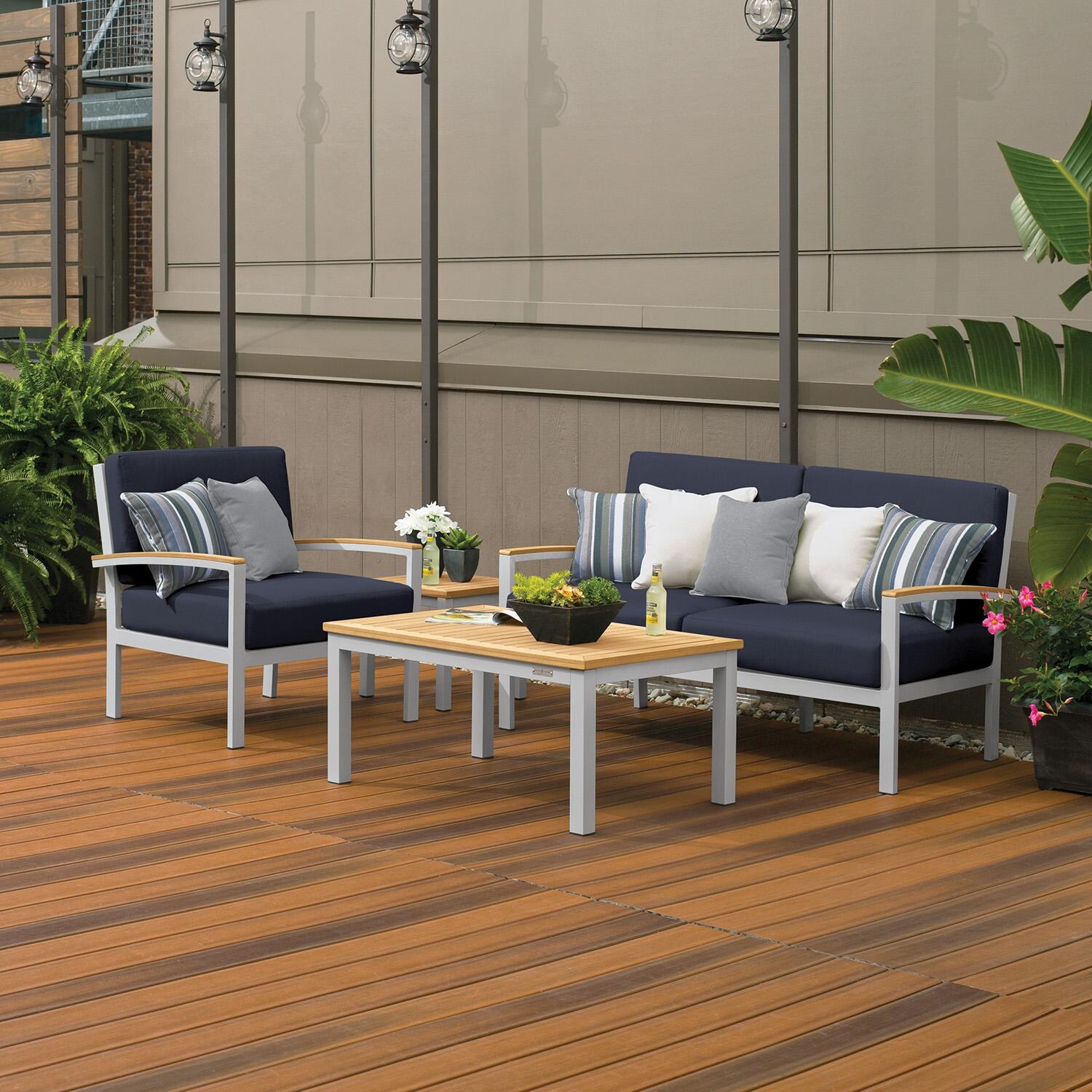 Oxford Garden 5255-PC.F Travira 4 Pc Aluminum Seating Set w/ Club Chair in Natural Tekwood/ Midnight Blue by Oxford Garden - On Patio by Fireplace - Lifestyle thumbnail
